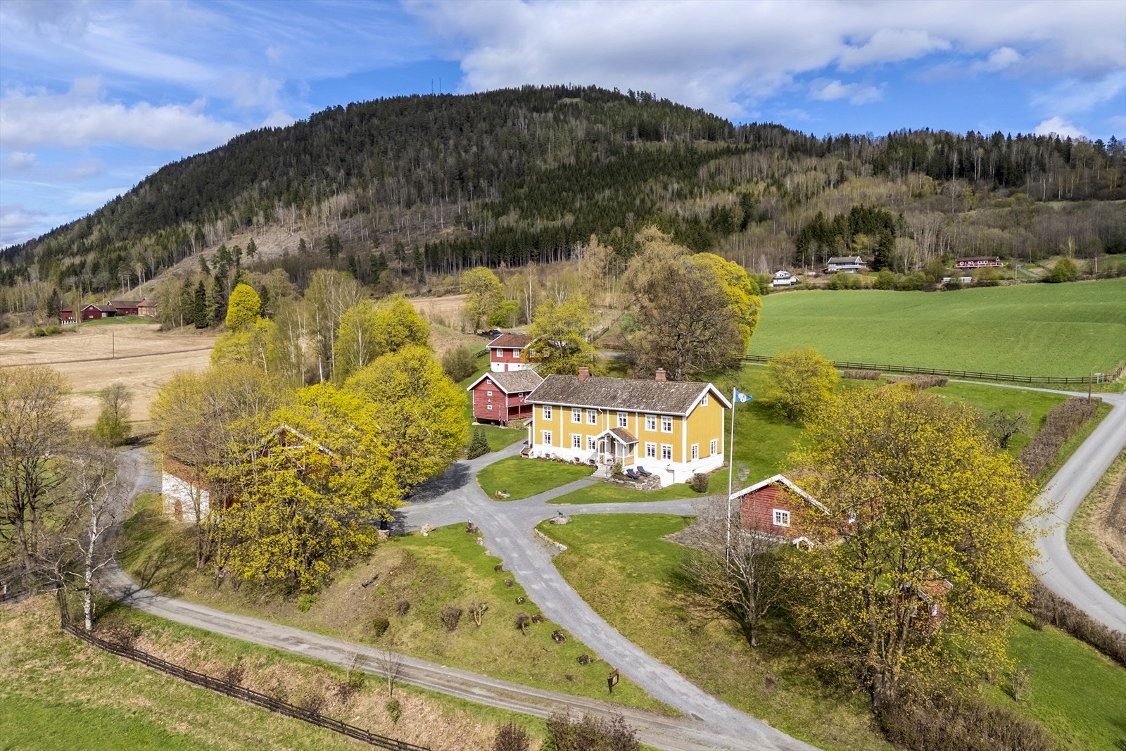 Rossmo ligger vakkert til i vesthellingen, med vidstrakt utsyn til Hadelands jordbrukslandskap Galleribilde