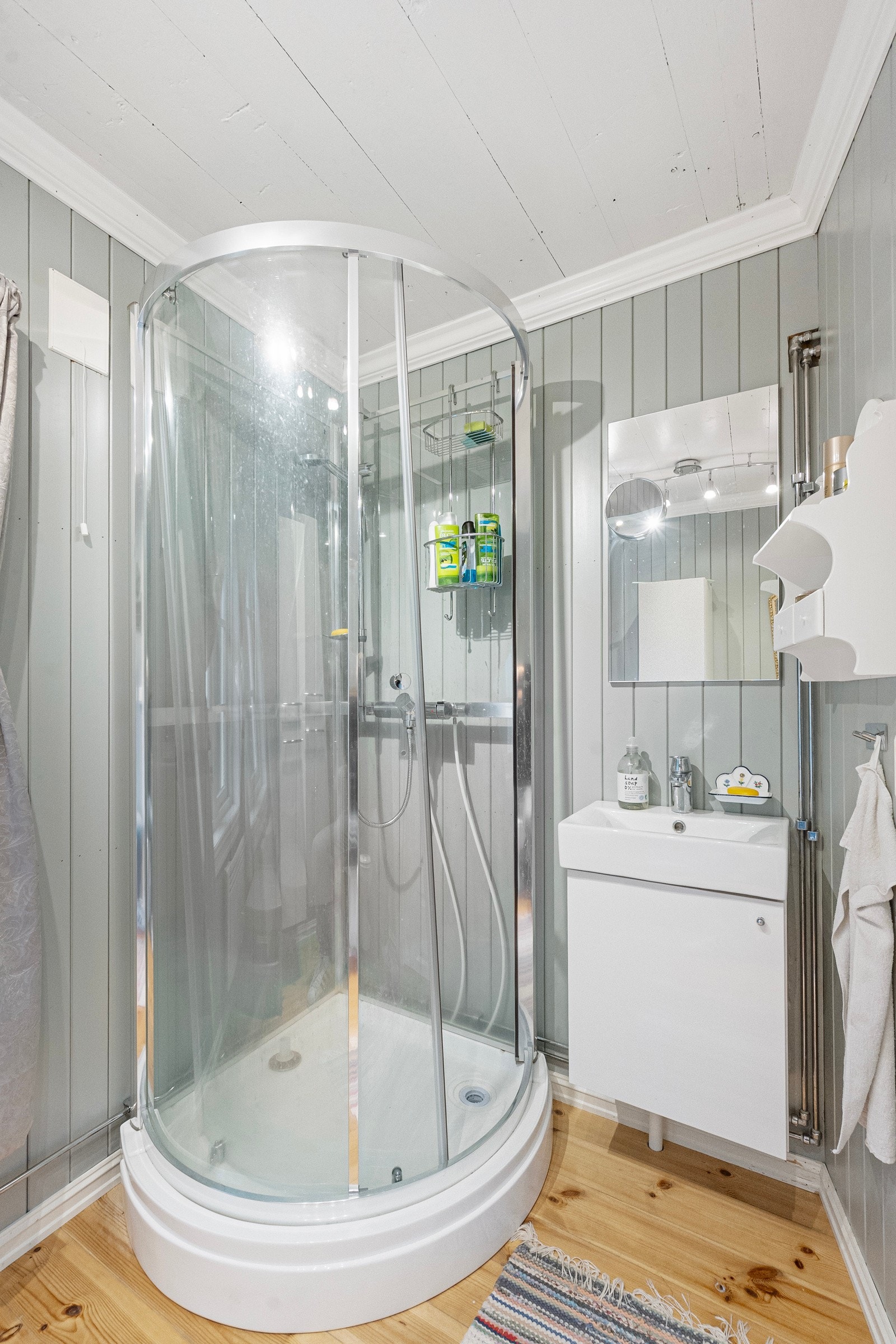 Badet er innredet med dusjkabinett, servant med skap, WC og opplegg for vaskemaskin Galleribilde