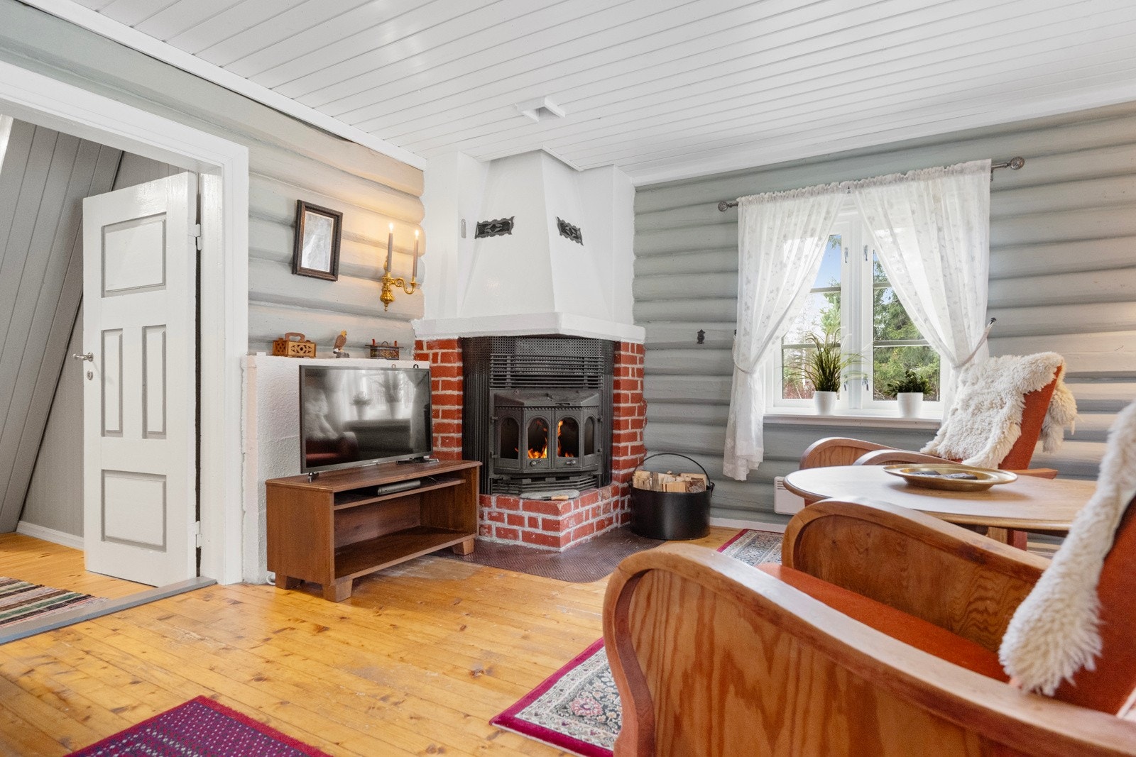 I peisstuen møter du lune tømmervegger, solide tregulv og en stemningsfull peis som sprer varme og hyttekos gjennom hele rommet Galleribilde