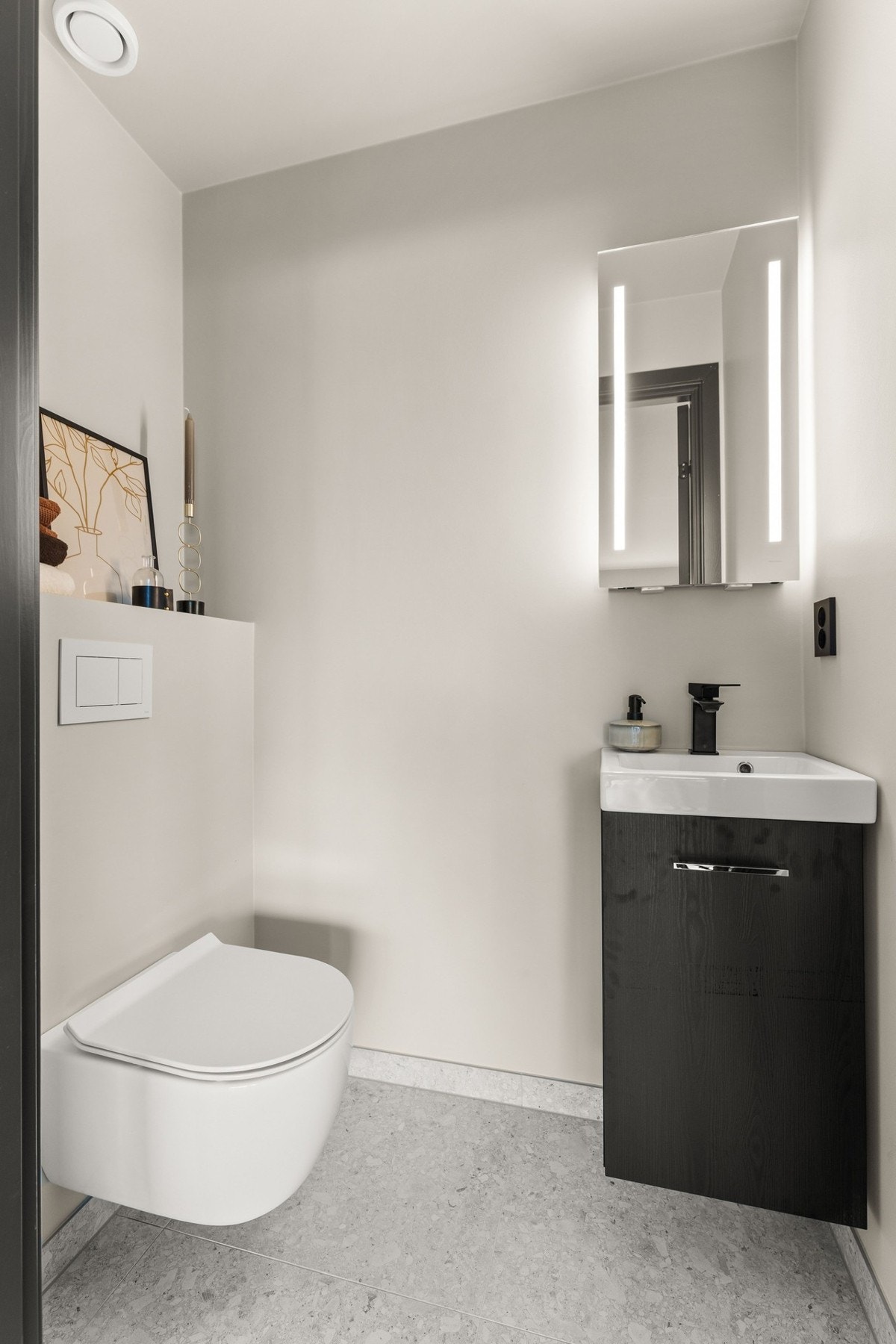 Lekkert gjestetoalett med moderne innredning, vegghengt toalett og stilrent servantskap. En funksjonell og gjennomført løsning i tidsriktige materialer. Galleribilde