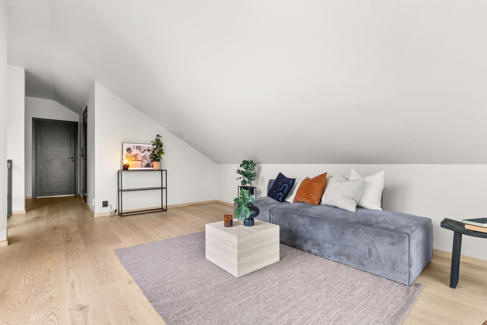 Lys og trivelig loftstue som gir et ekstra oppholdsrom til lek, avslapning eller TV-krok. Overflatene er holdt i samme gjennomførte stil som resten av boligen. Galleribilde