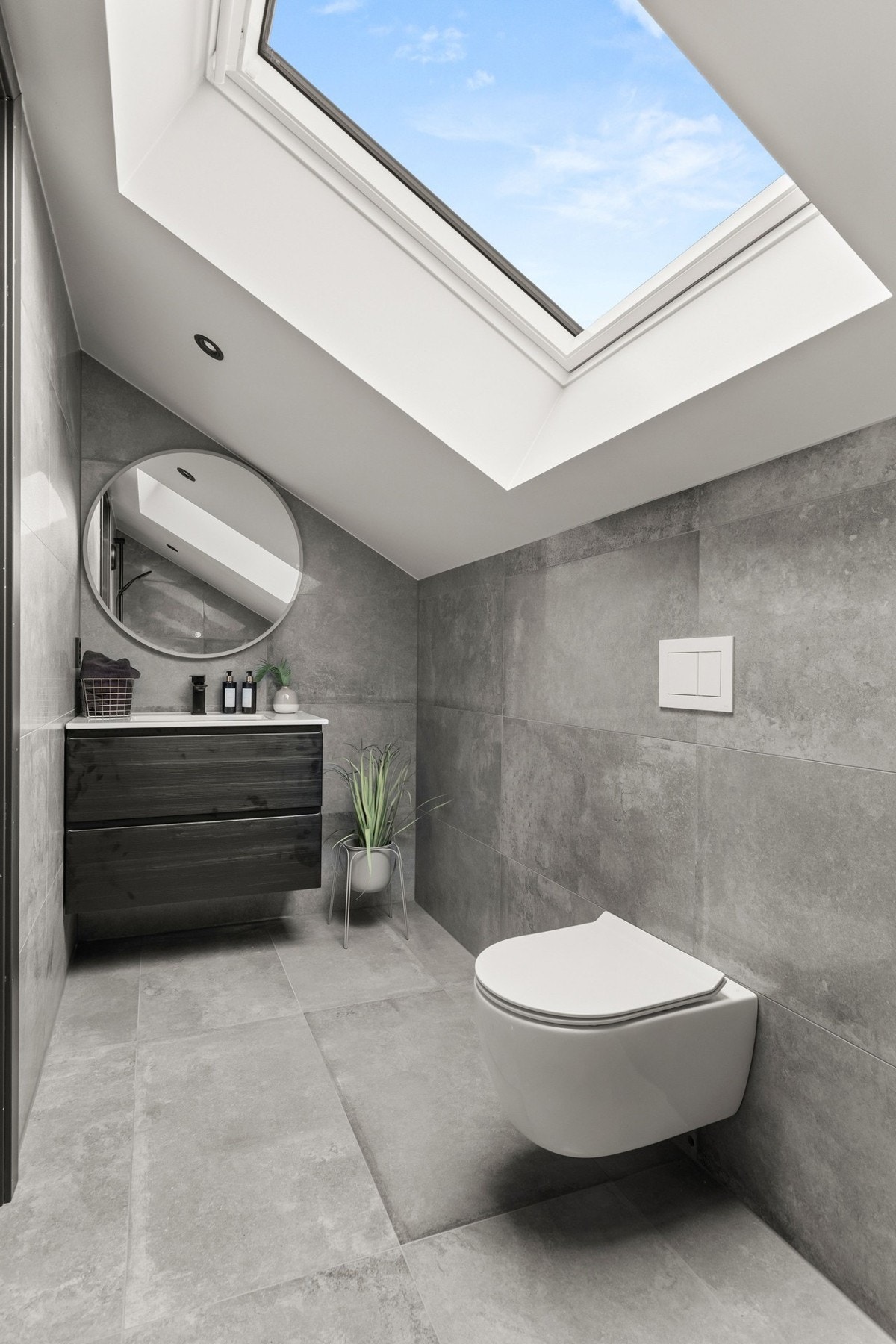 Delikat bad med flislagt gulv og varmekabler, moderne innredning og gjennomførte materialvalg. Galleribilde