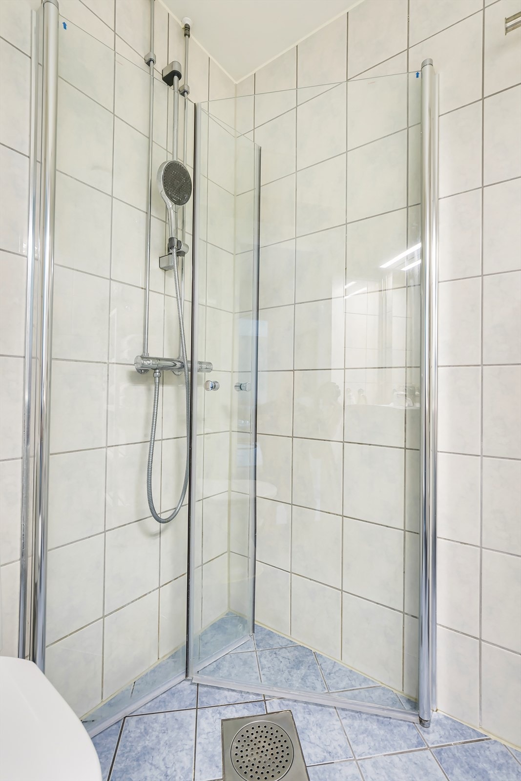 Badet er innredet med servantskap, dusjsone, speil og toalett. Galleribilde