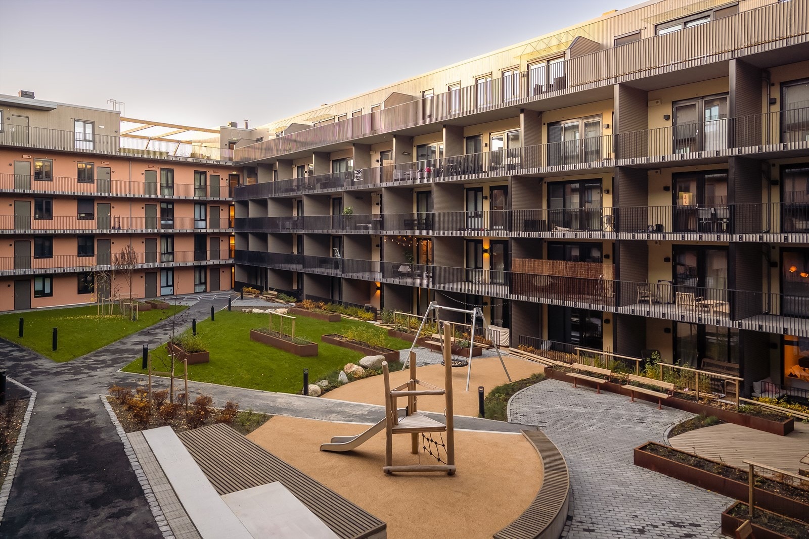 Bakgården byr på pene fellesarealer med grønne omgivelser, lekeplasser og hyggelige sittegrupper. Galleribilde