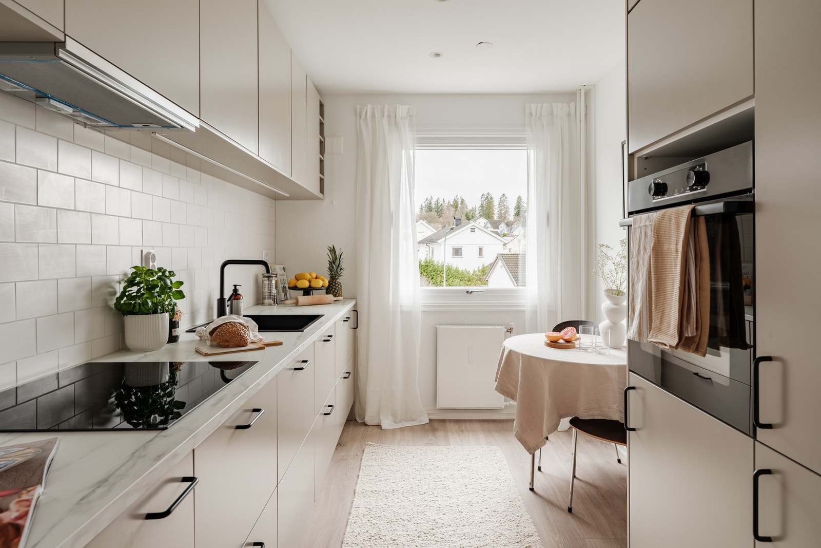Pent kjøkken med slette fronter og laminat benkeplate. Galleribilde