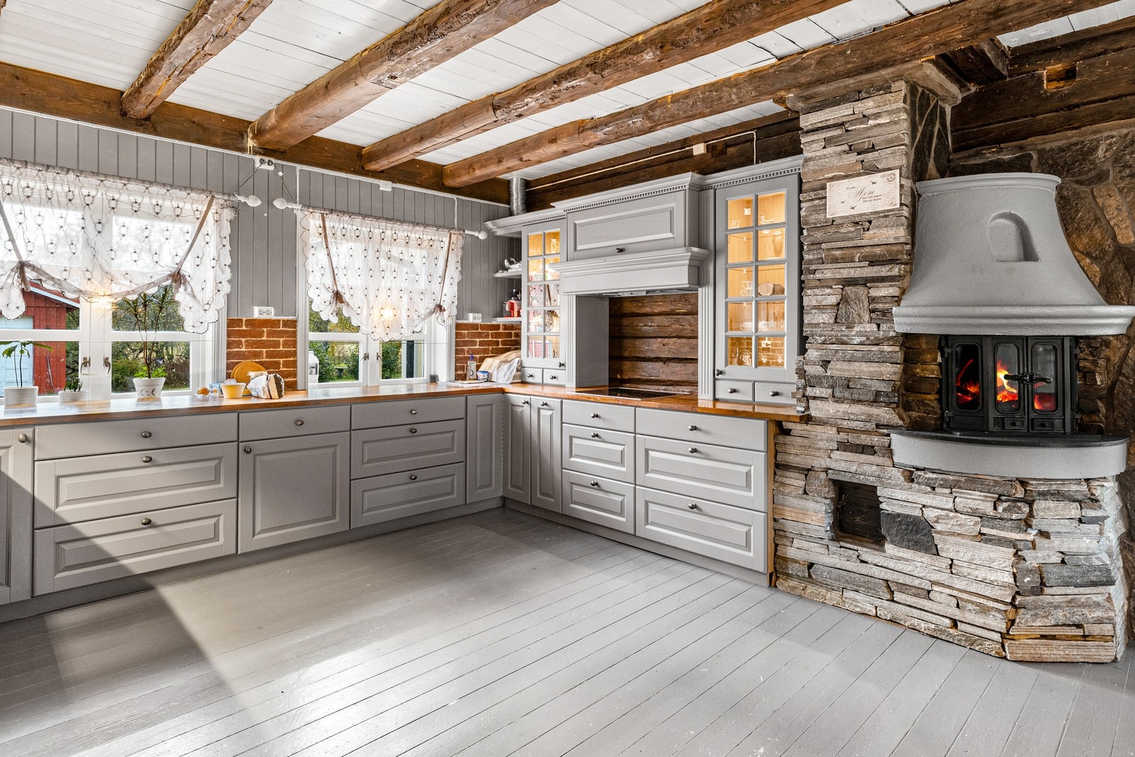 Kjøkkenet har en harmonisk miks av moderne og rustikke elementer Galleribilde