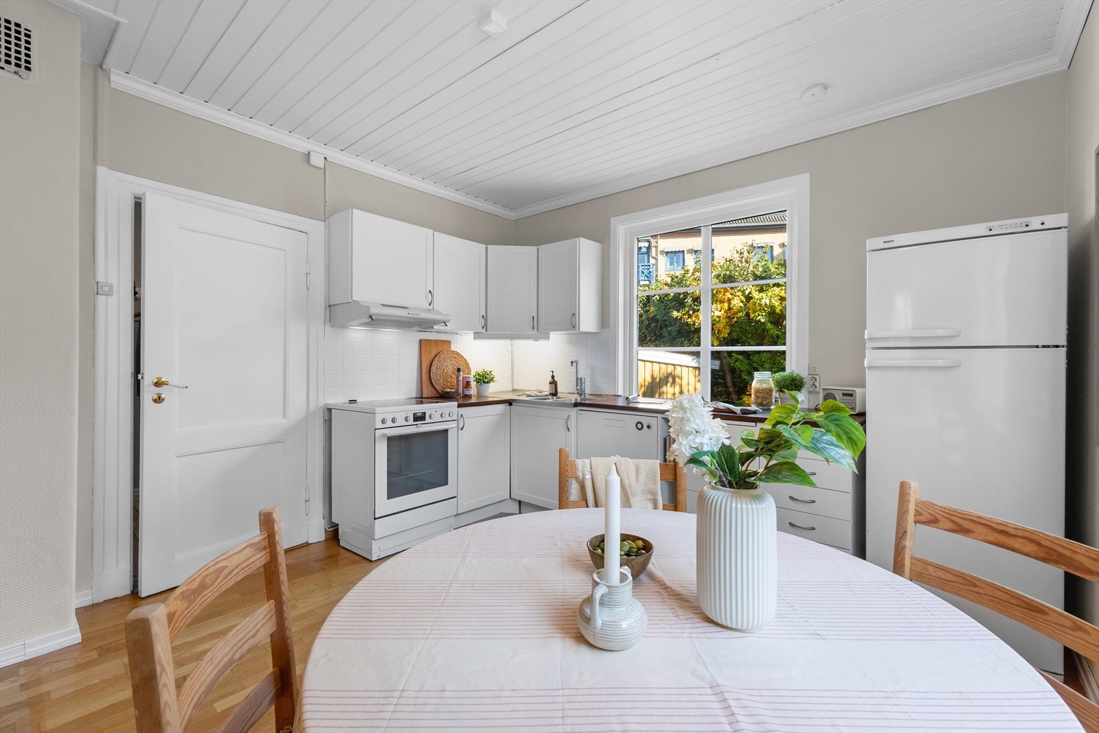 Fra kjøkkenet er det hyggelig utsikt ut i hagen og enkelt å følge med på små barn som leker. Galleribilde