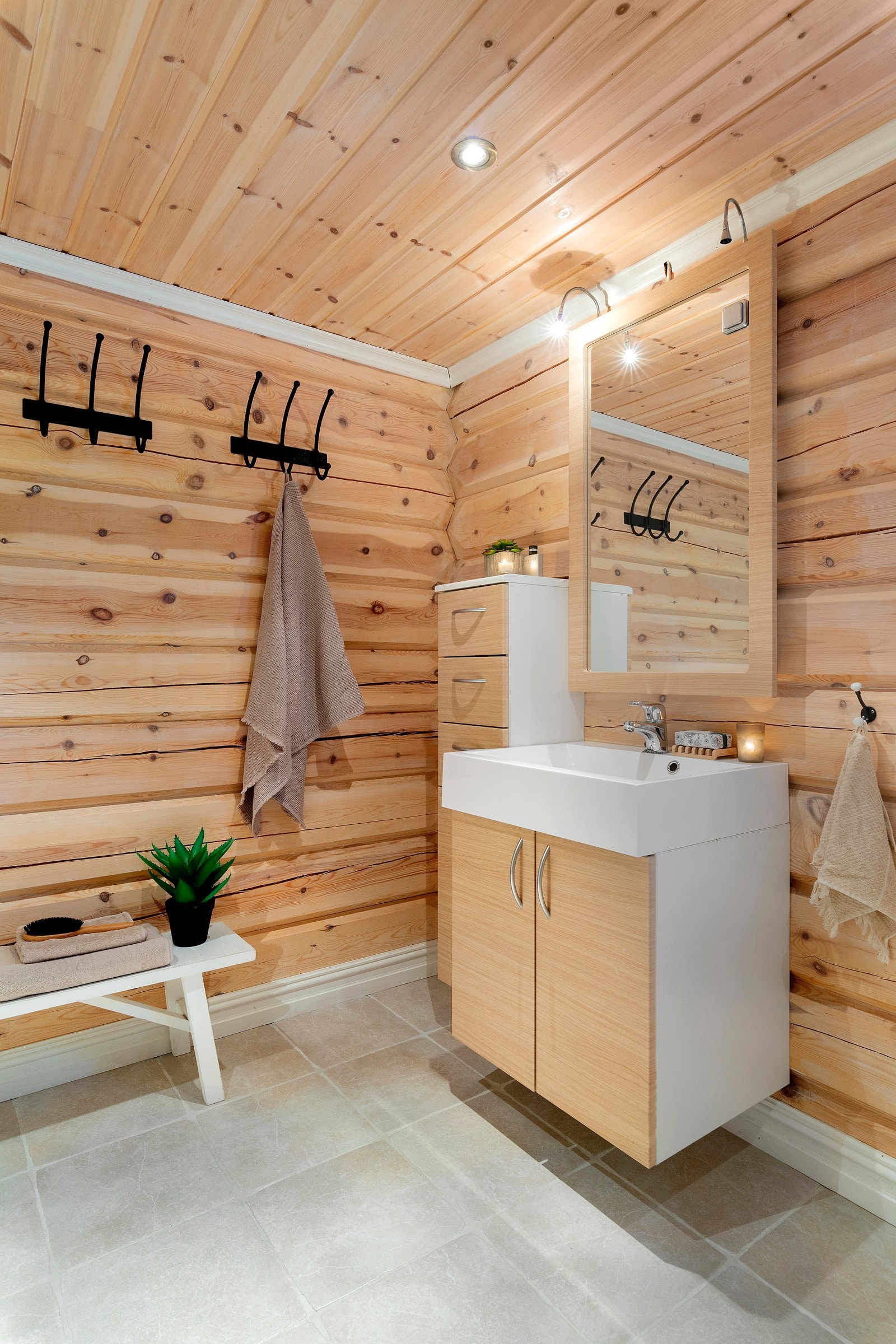 Innredning med servant med høyskap på siden. Speil over med belysning. Galleribilde