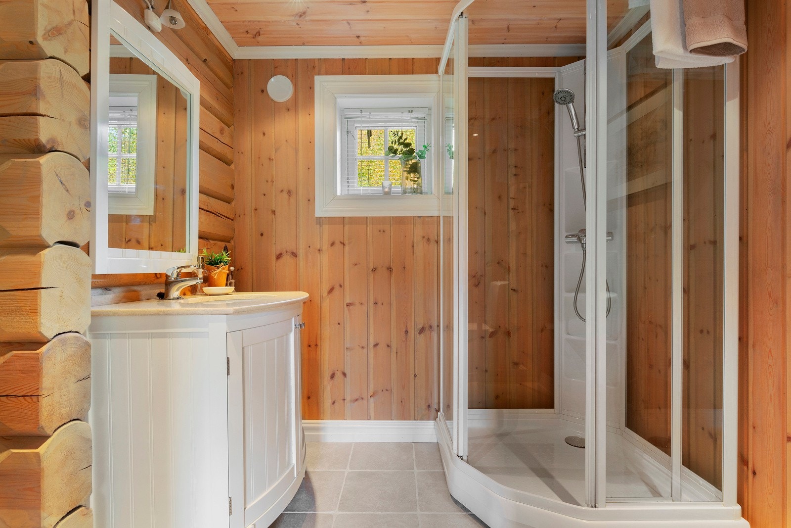 Bad nummer har også flis på gulvet og tømmer/panelvegger. Her er dusjkabinett, innredning med servant - Galleribilde