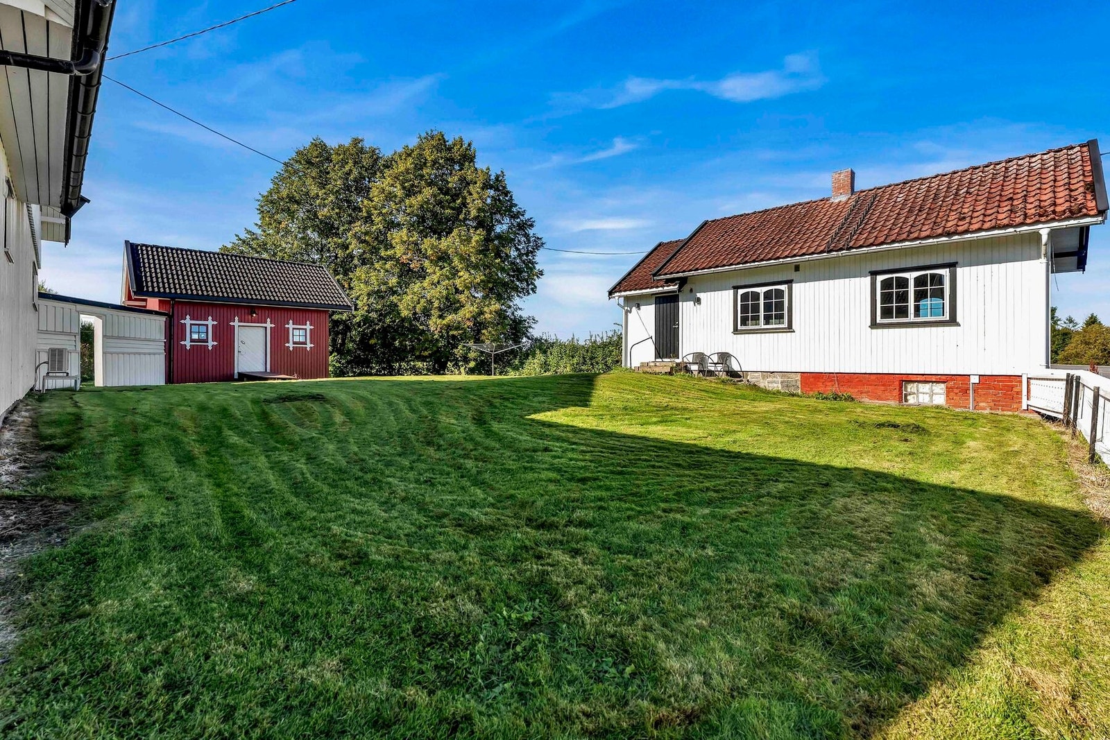 Det er romslige plenarealer mellom hovedhuset og sidebygningen Galleribilde