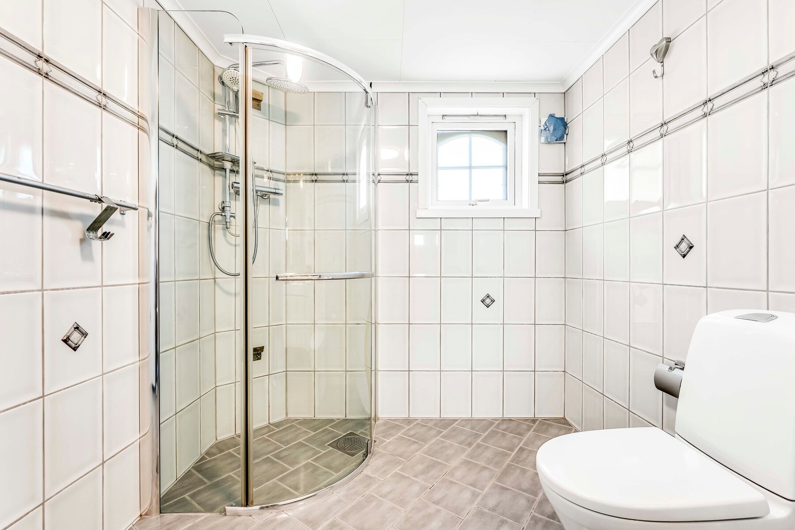 Badet i første etasje med fliser på gulv og vegger Galleribilde