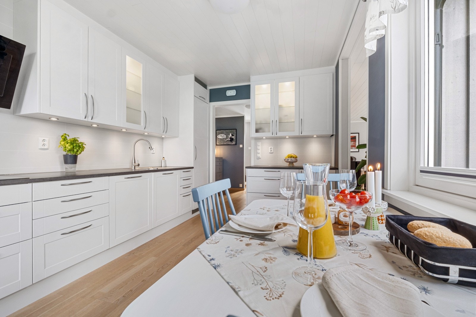 Det er enkelte overskap med glassdører og integrert belysning, samt downlights over benk som lyser opp arbeidssonen Galleribilde