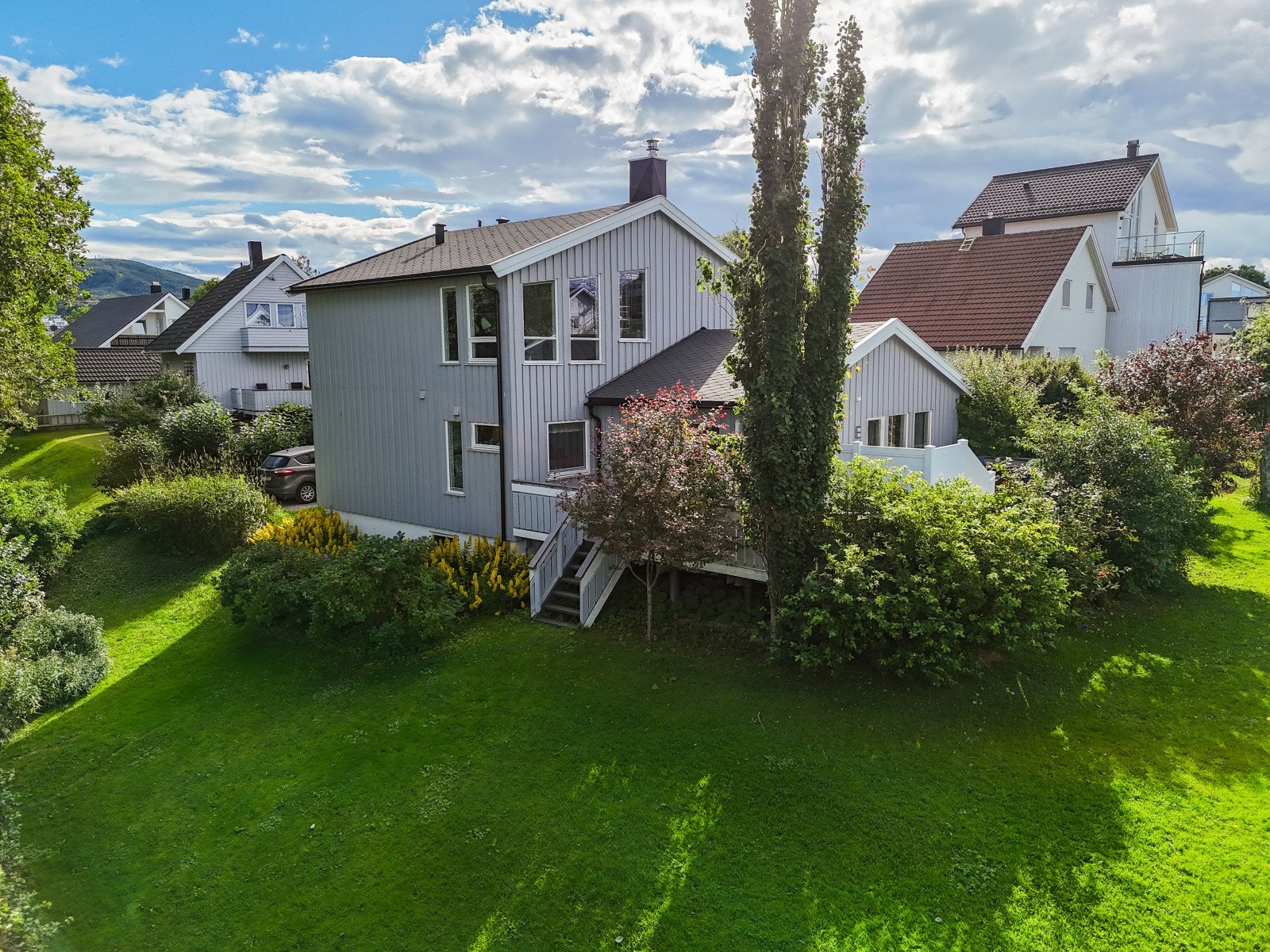 Boligen byr på en solrik vestvendt terrasse med nedgang til en frodig hage med bl.a. plen, epletre, kirsebærtre og plommetre Galleribilde