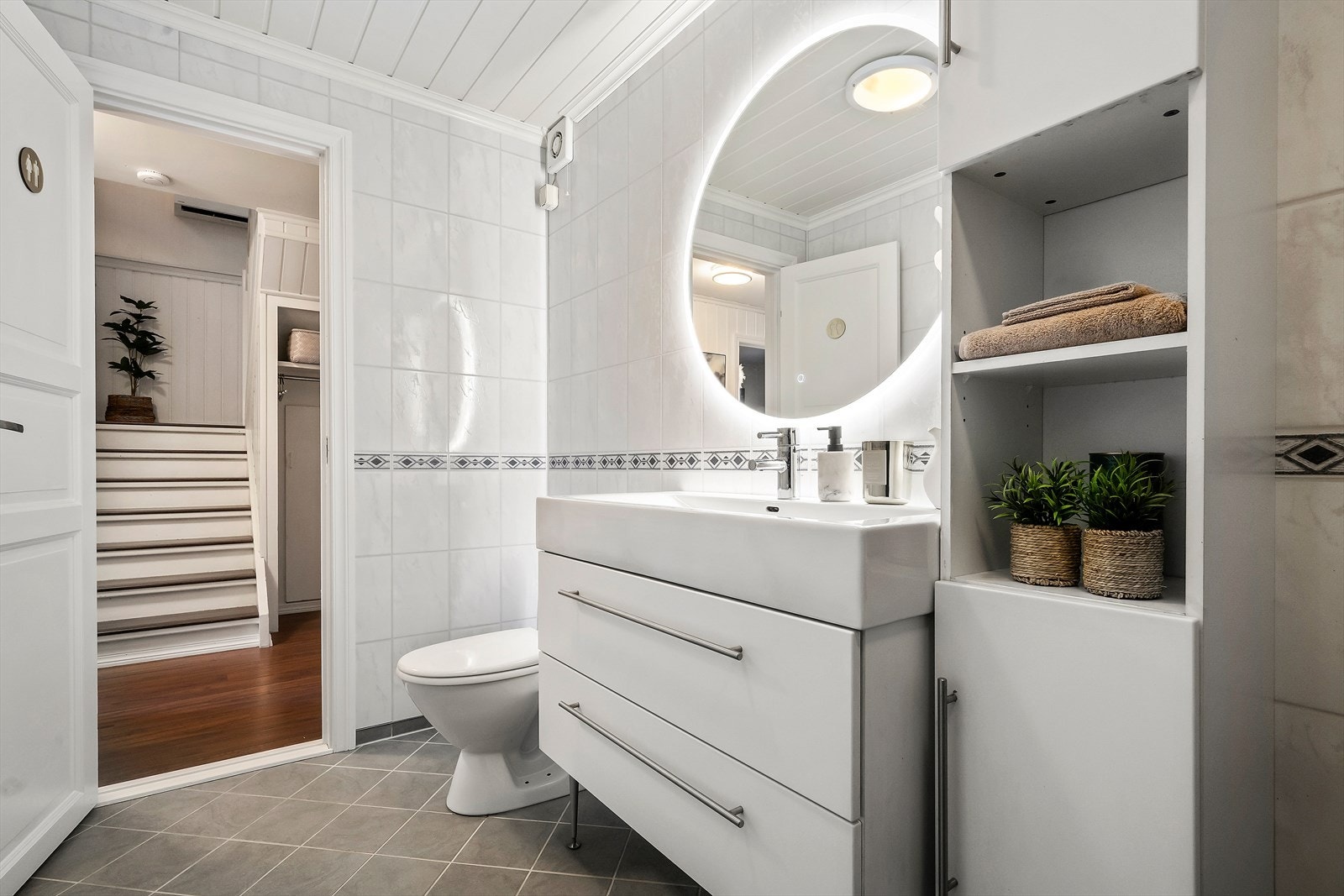 Badet er innredet med dusjdører, toalett og innredning med servant. Galleribilde