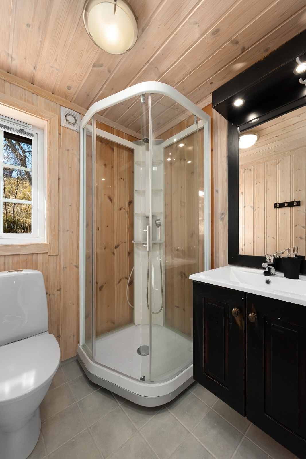 Praktisk bad nummer to med dusjkabinett, servantinnredning med speil og toalett. Galleribilde