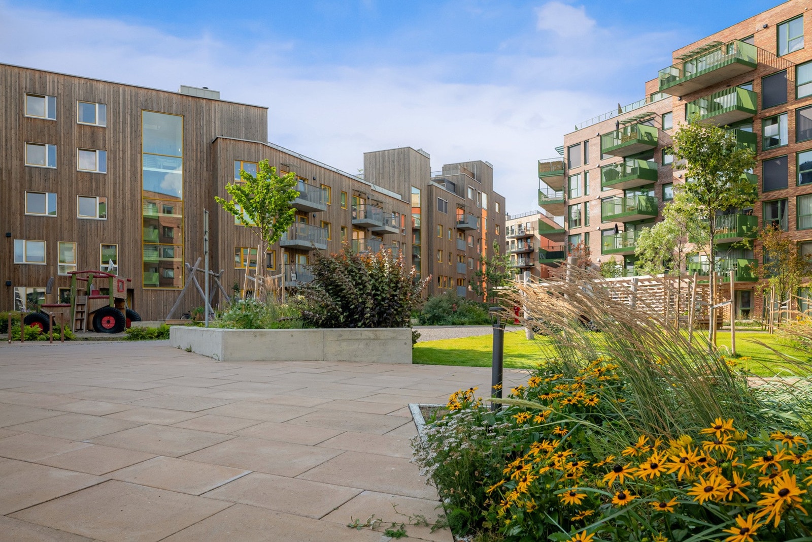 Fellesarealene er pent opparbeidet med sitteplasser, lekeplasser og beplantning Galleribilde