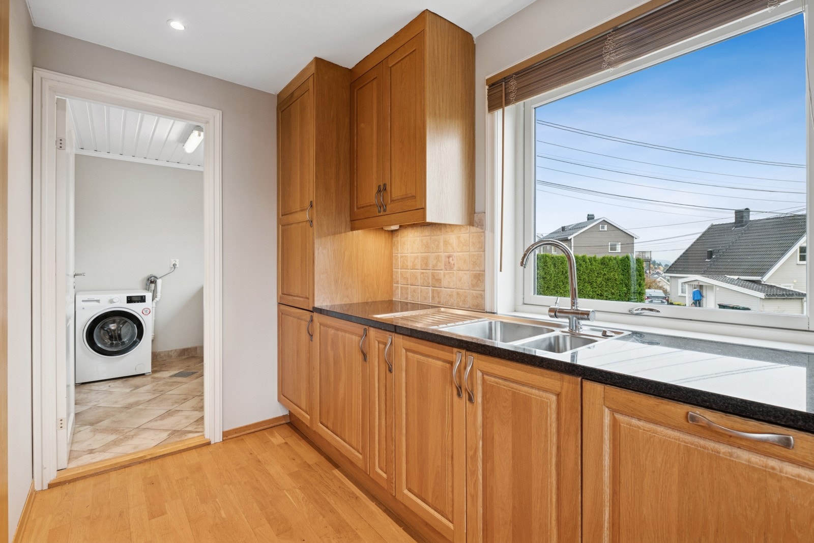 Smart løsning med vaskerom rett ved kjøkkenet - perfekt for familieliv Galleribilde