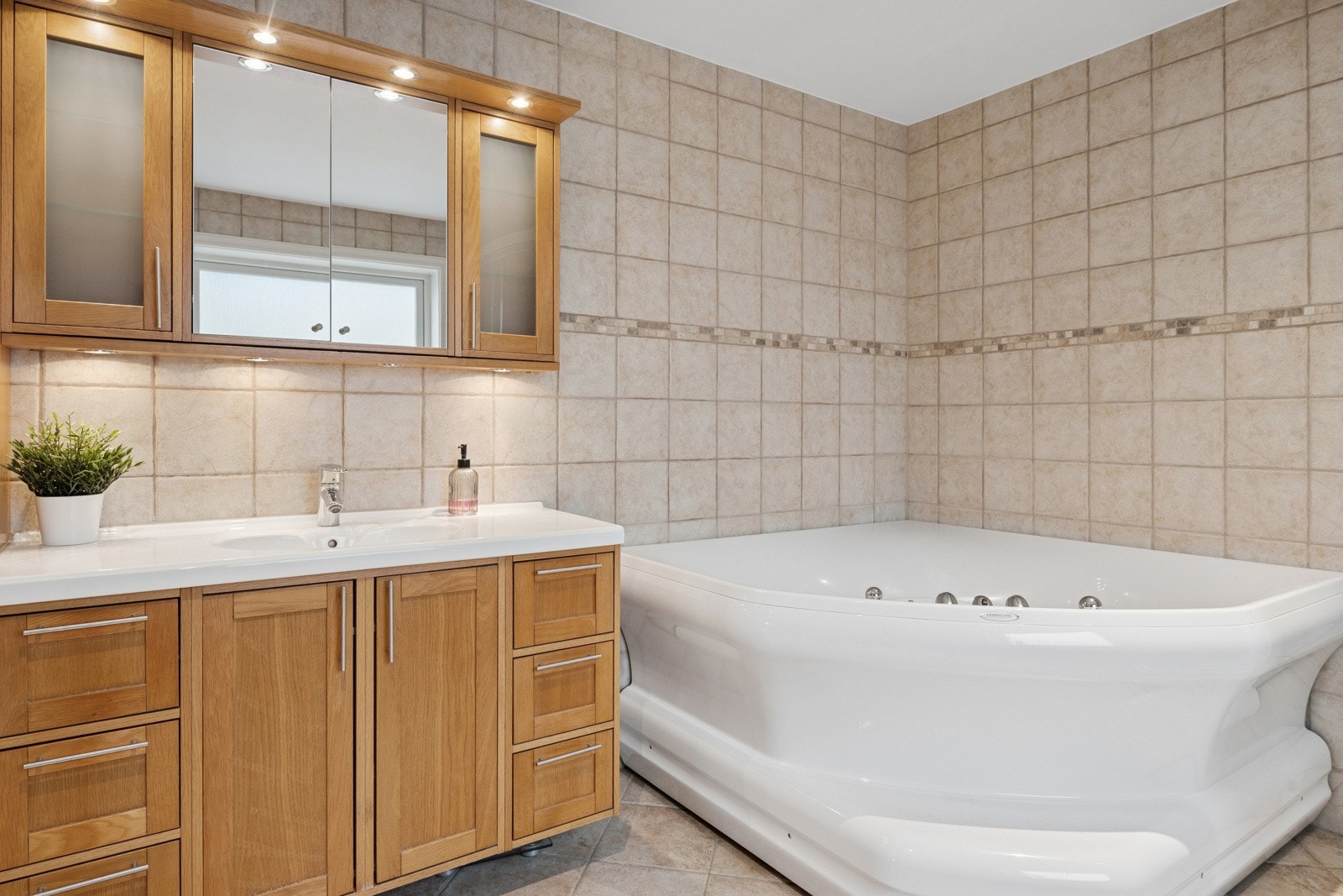 Flislagt bad med solid servantinnredning i tre og rikelig plass til oppbevaring. Galleribilde