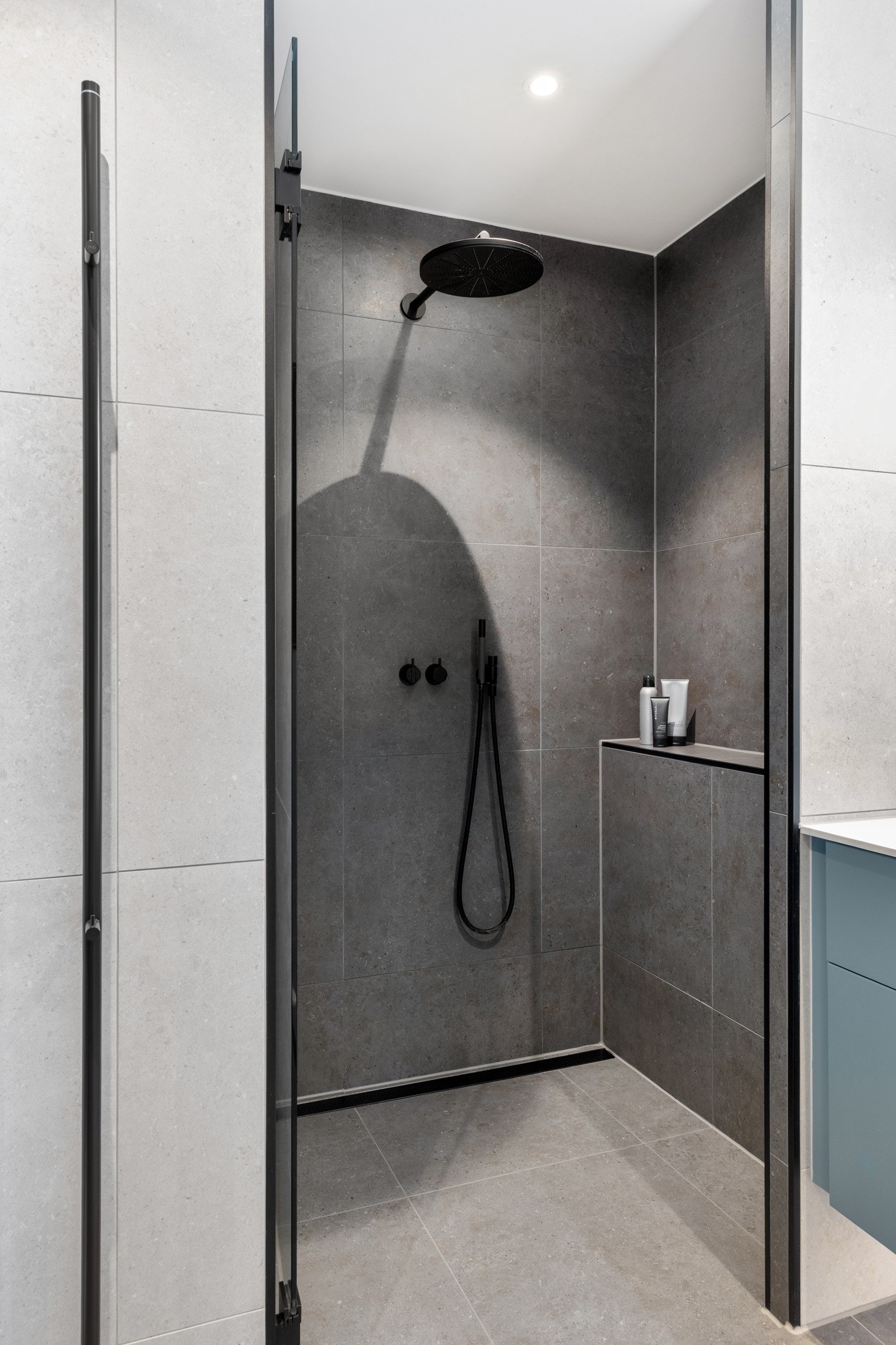 2. etasje: Badet har romslig dusjnisje med glassdør samt regnfallsdusj og hånddusj fra eksklusive Vola. Elektrisk håndklevarmer fra INR Line. Hylle til baderomsprodukter og rennesluk fra Purus type Pearl Galleribilde