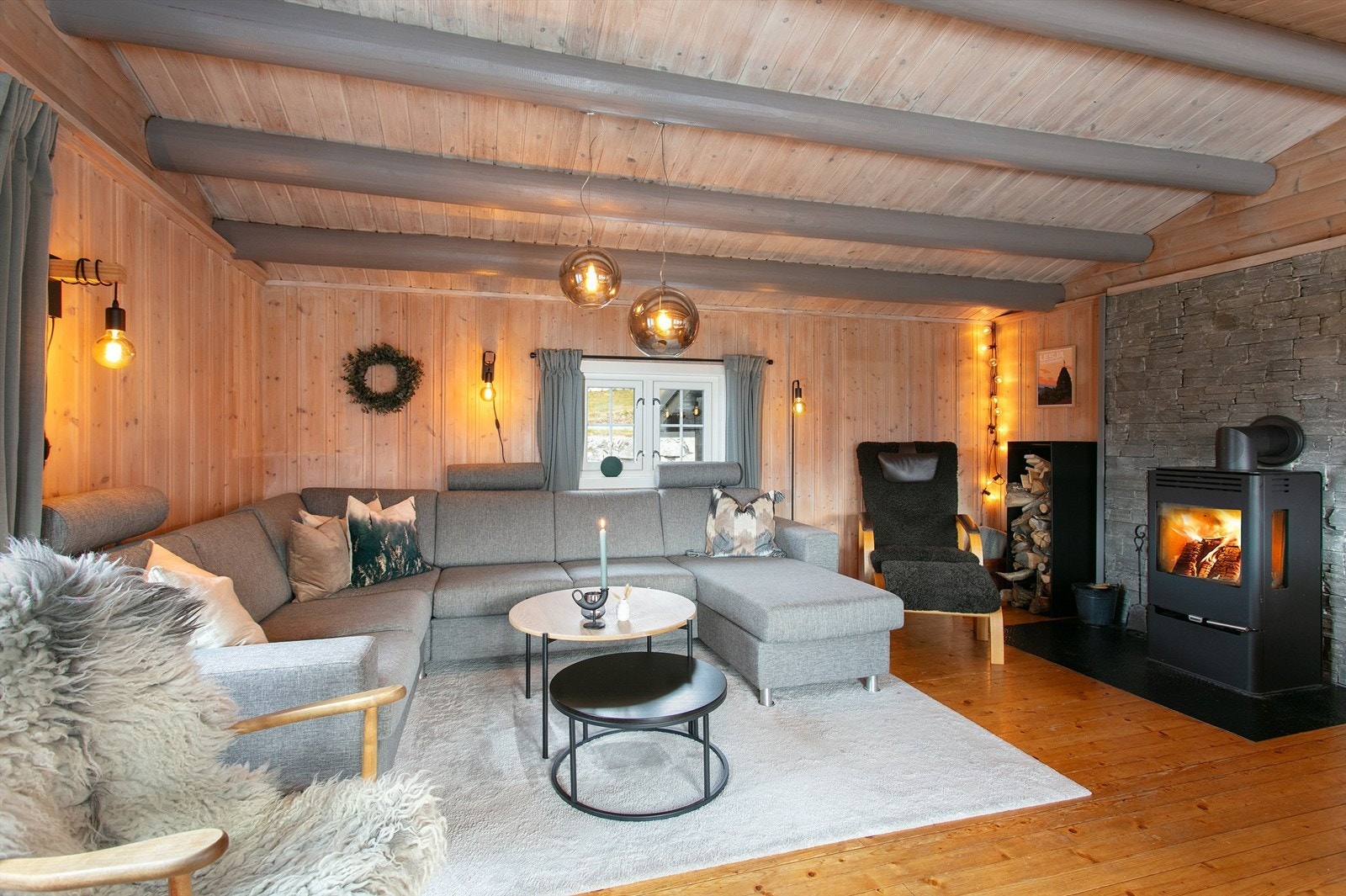 Det er peisovn med glassdør i stuen som gir en lun og hyggelig atmosfære på kjølige kvelder Galleribilde