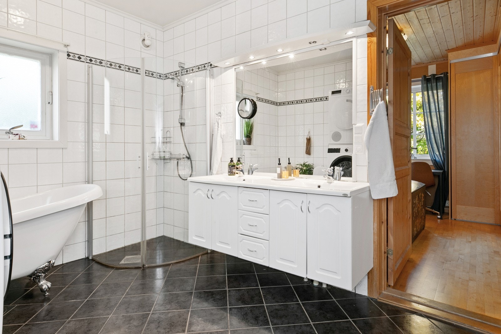 Det er innredet med servantinnredning, dusjhjørne, badekar og opplegg for vaskemaskin Galleribilde