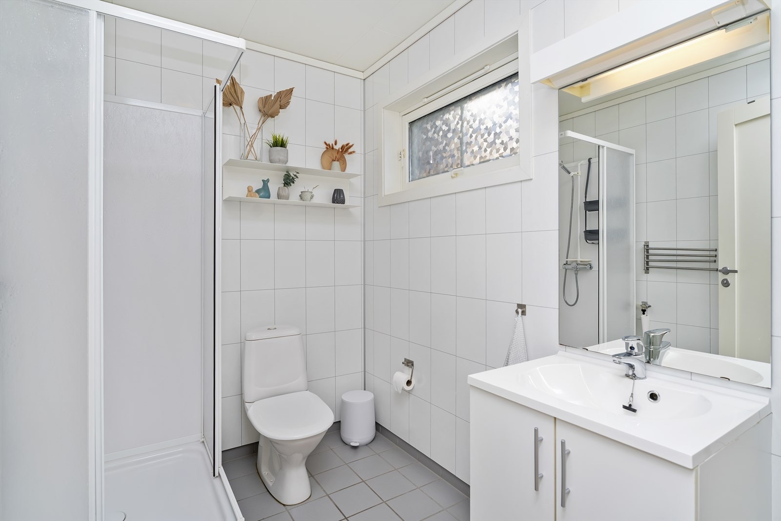 Badet/vaskerommet er utstyrt med innredning med nedfelt servant, dusjkabinett, toalett og opplegg for vaskemaskin Galleribilde