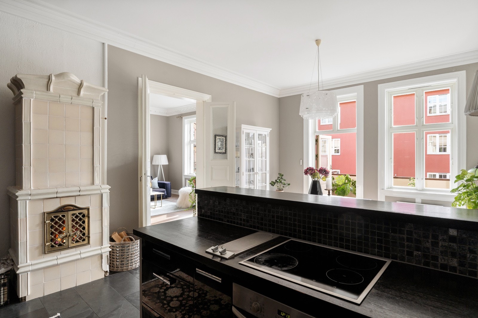 Ved siden av kjøkkenet står en sjarmerende kakkelovn som skaper en flott kontrast til det moderne uttrykket Galleribilde