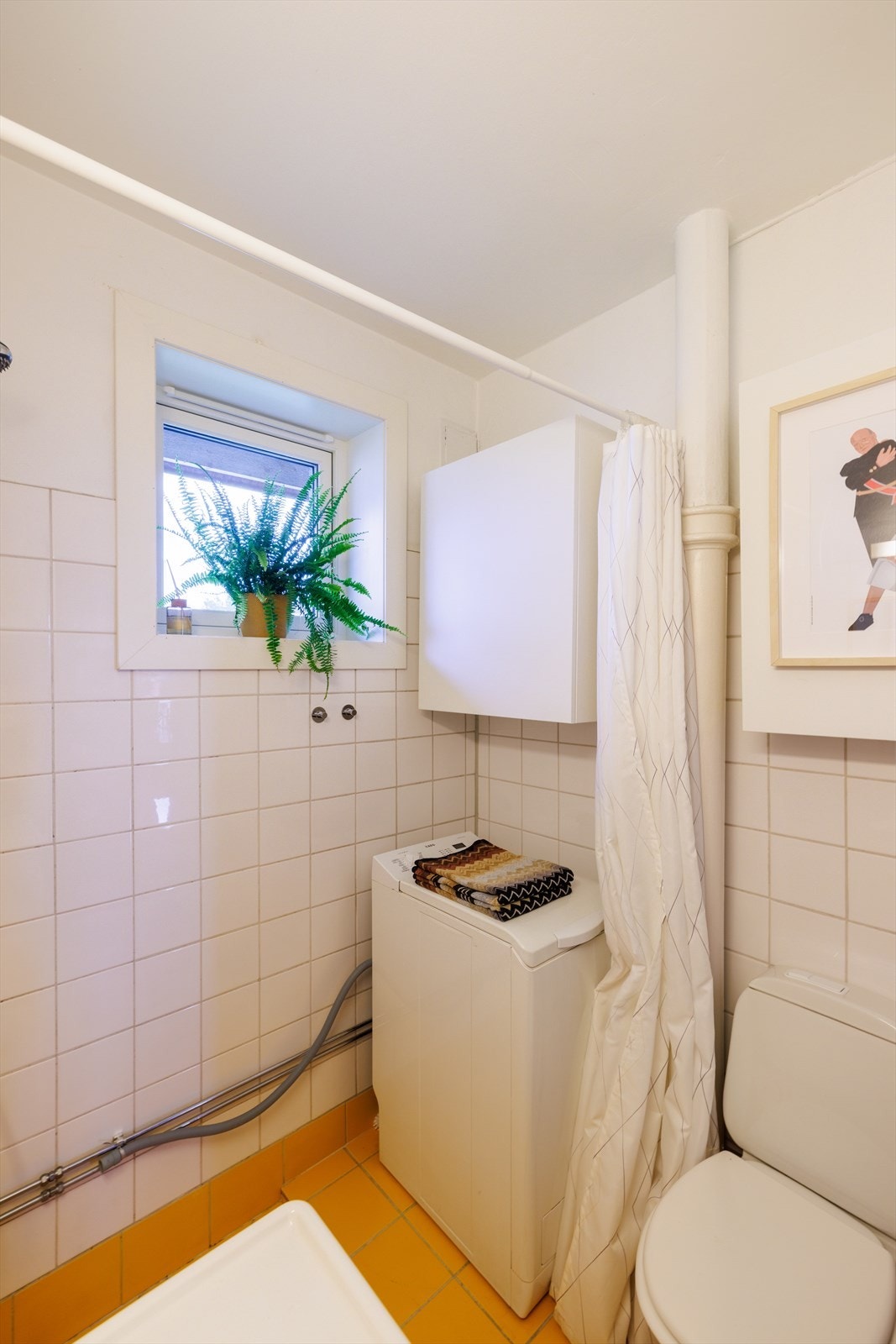 Rommet er utstyrt med dusj på gulv, gulvstående toalett og opplegg for vaskemaskin. Galleribilde