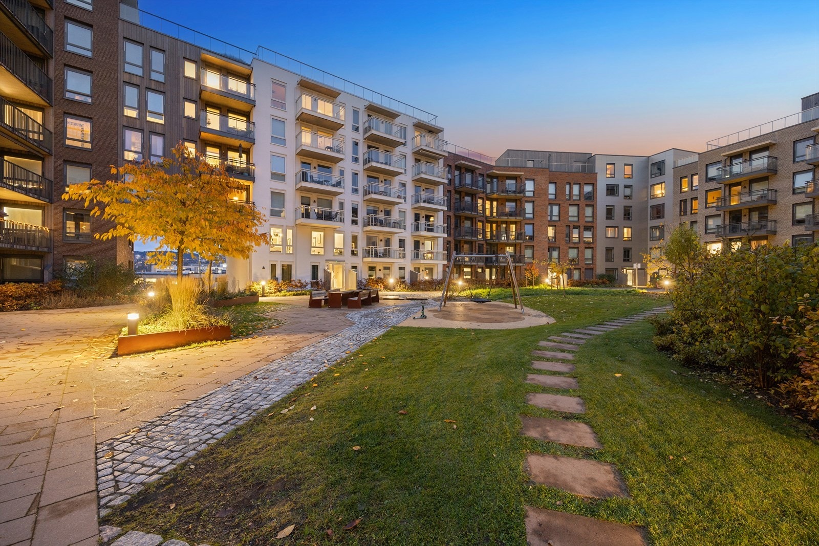 Rolig og frodig bakgård med lekeplass, sitteplasser og god plass for lek og hygge for både små og store. Galleribilde