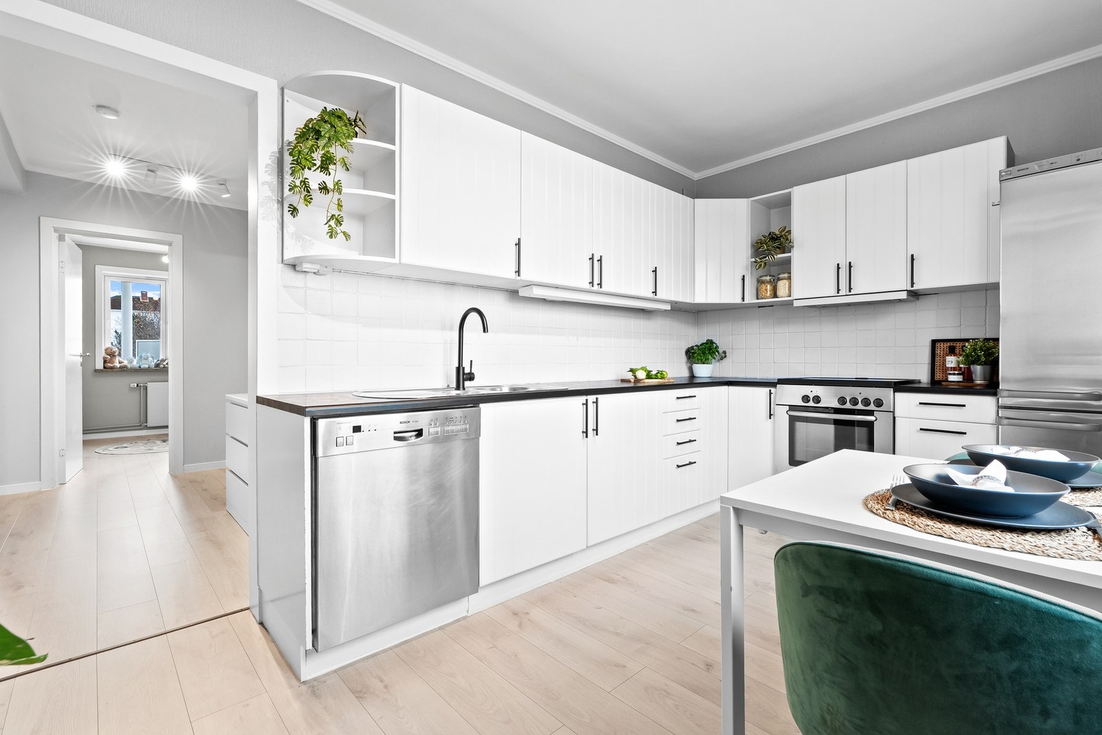 Innredningen har lyse fronter og videre er kjøkkenet utstyrt med frittstående kjøle-/fryse-skap, komfyr, samt ventilator og opplegg for oppvaskmaskin. Galleribilde