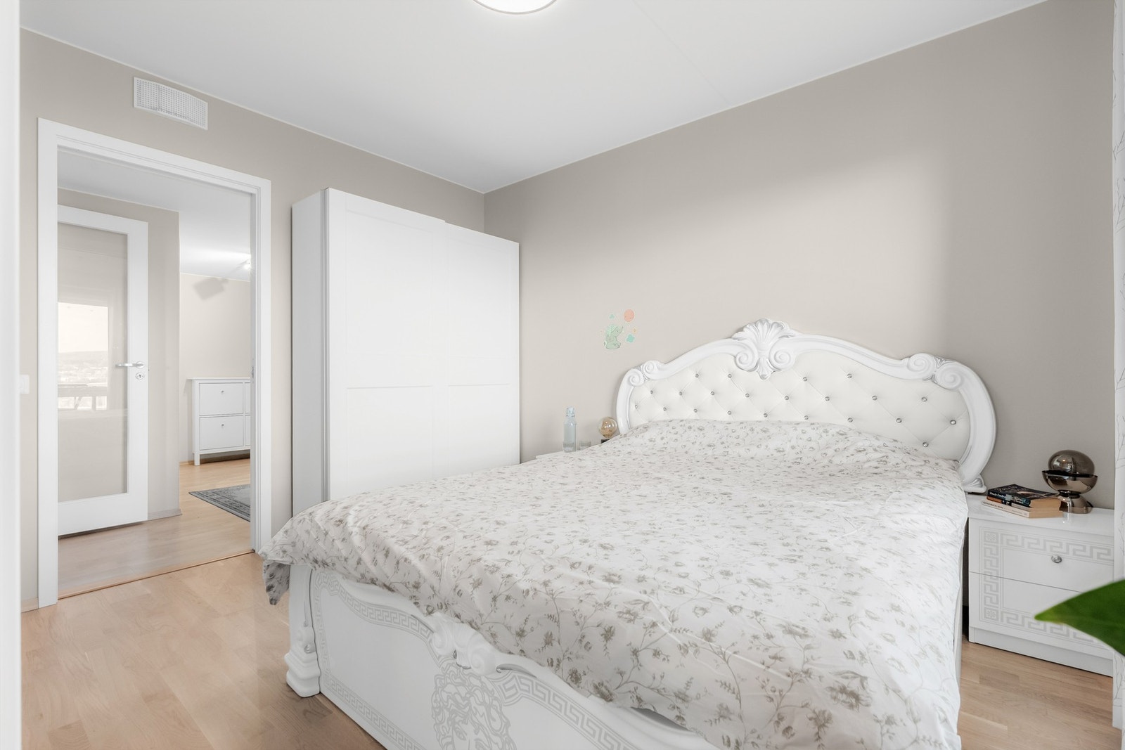 Behagelig hovedsoverom med nøytrale fargetoner og utgang til balkong som gir en luftig og harmonisk atmosfære. Galleribilde