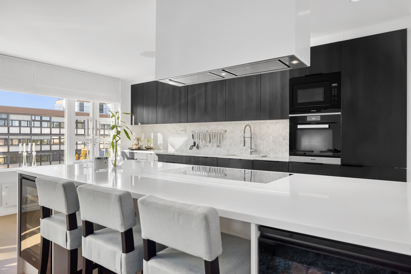 Kjøkkenet har Corian benkeplate og marmorfliser på vegg mellom benk og overskap.