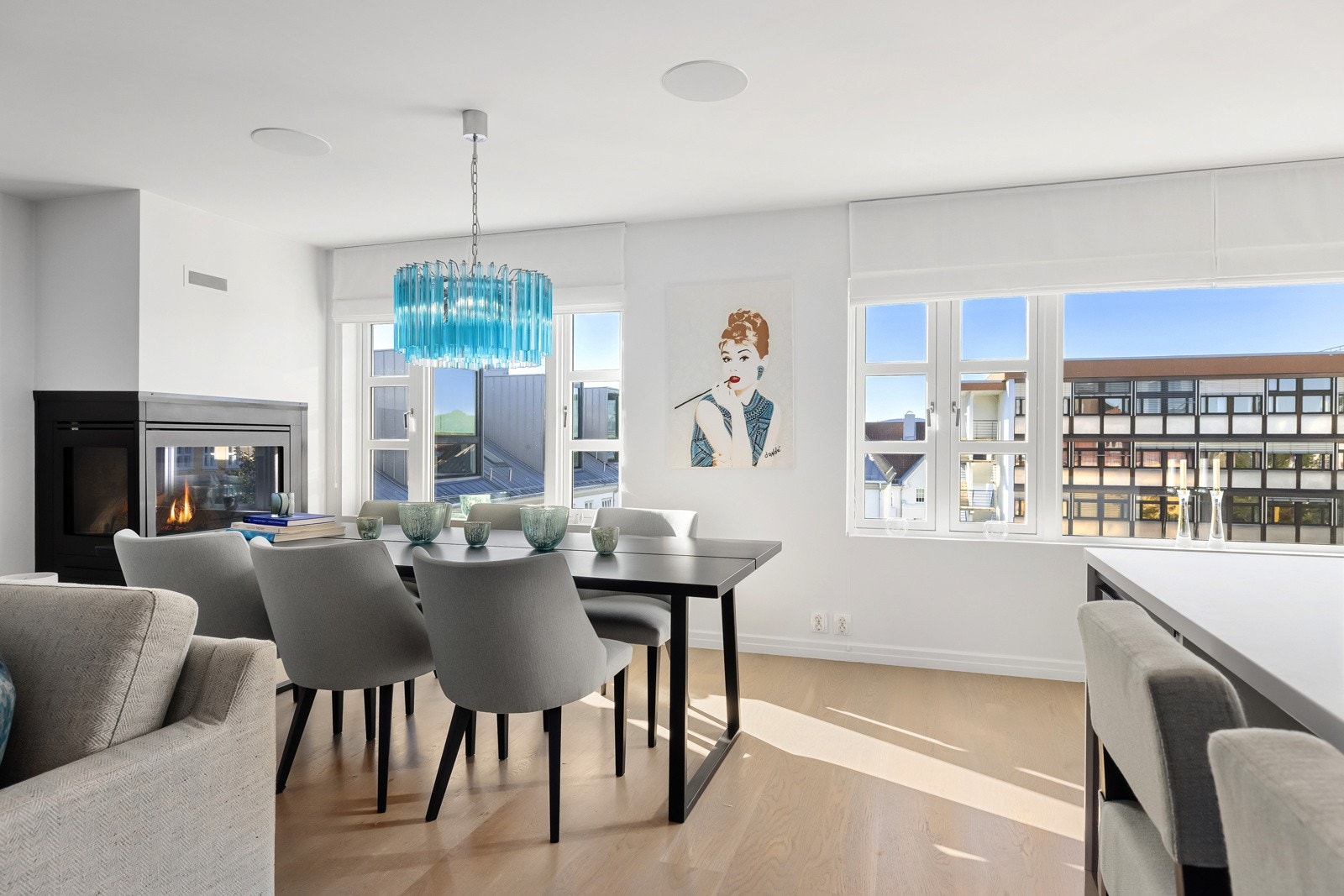 Store vindusflater i stuen, slipper mye lys og himmel inn i rommet. Stor hjørnepeis er med på å skape den rette stemningen.