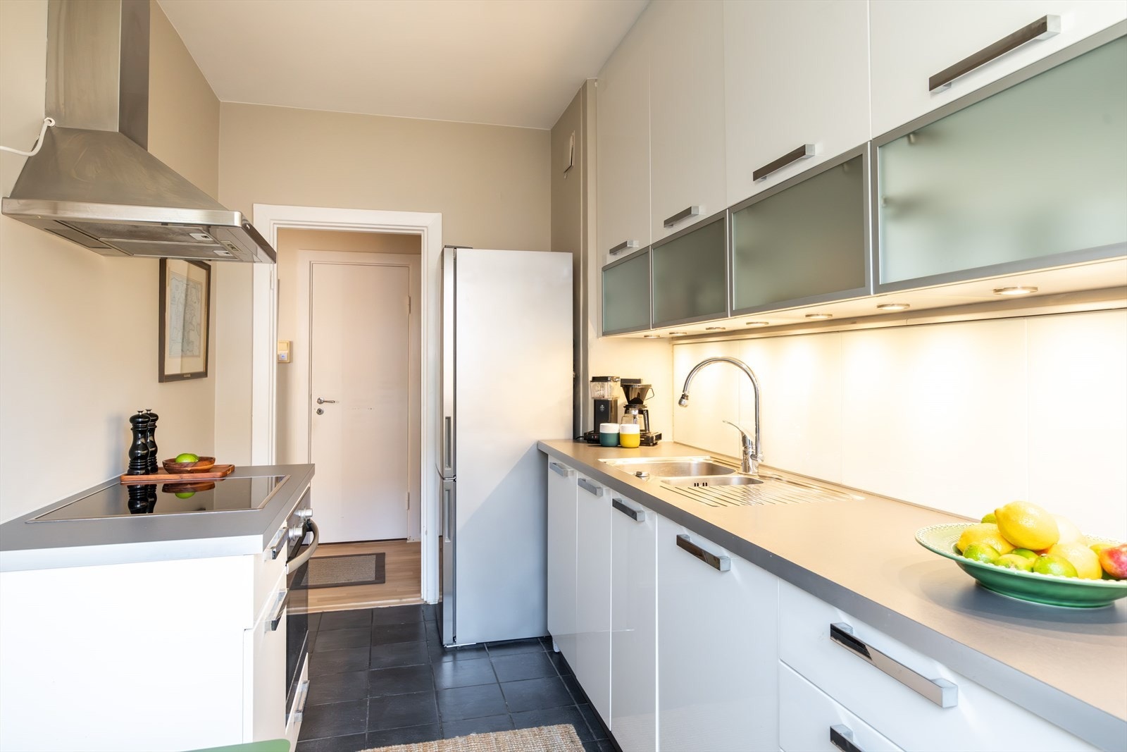 Videre er kjøkkenet utstyrt med integrert oppvaskmaskin, platetopp og stekeovn - godt med skap- og benkeplass! Galleribilde