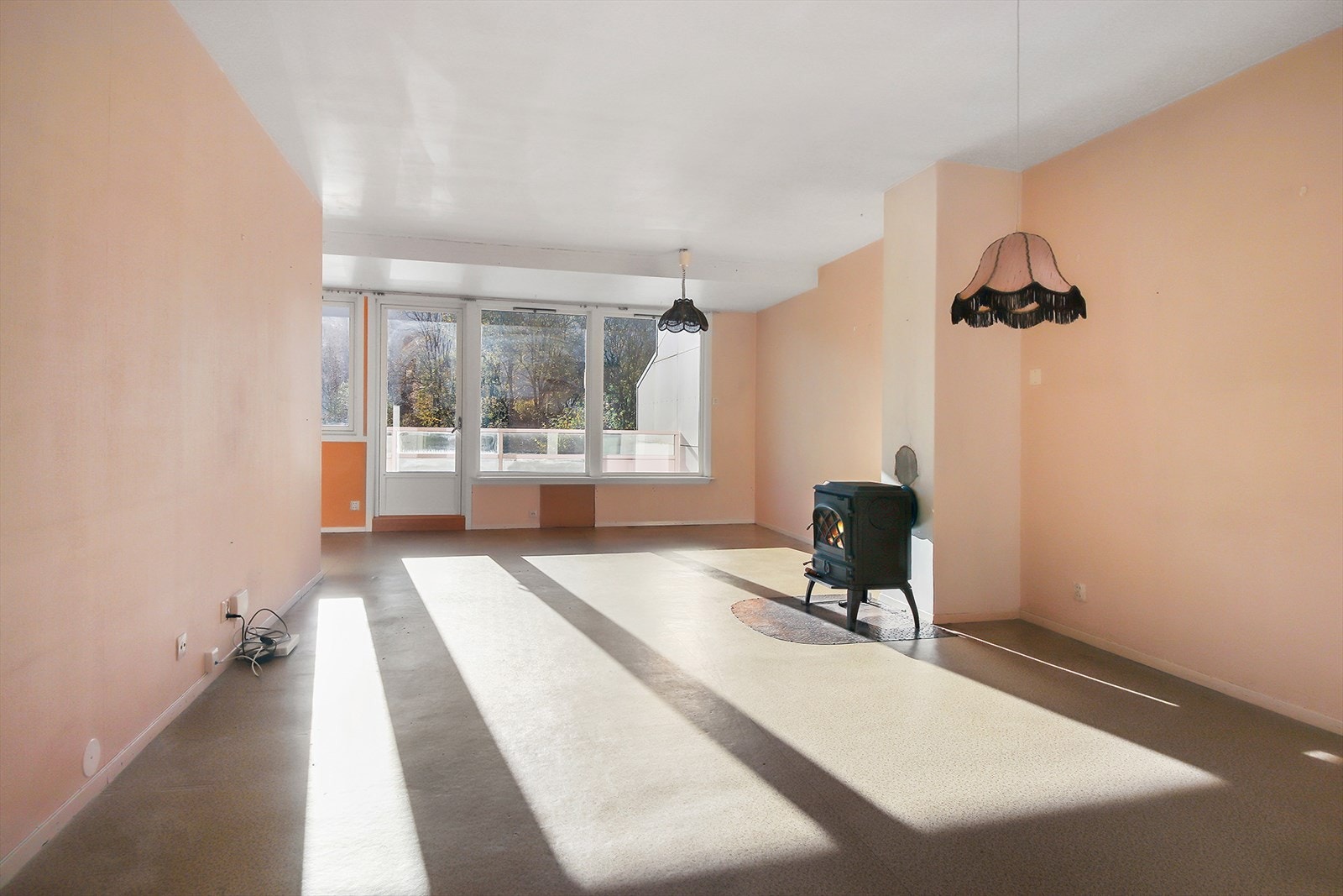 Romslig stue med rom for sittegruppe. Her finner man også en vedovn som tilbyr lun varme på kalde vinterdager. Galleribilde