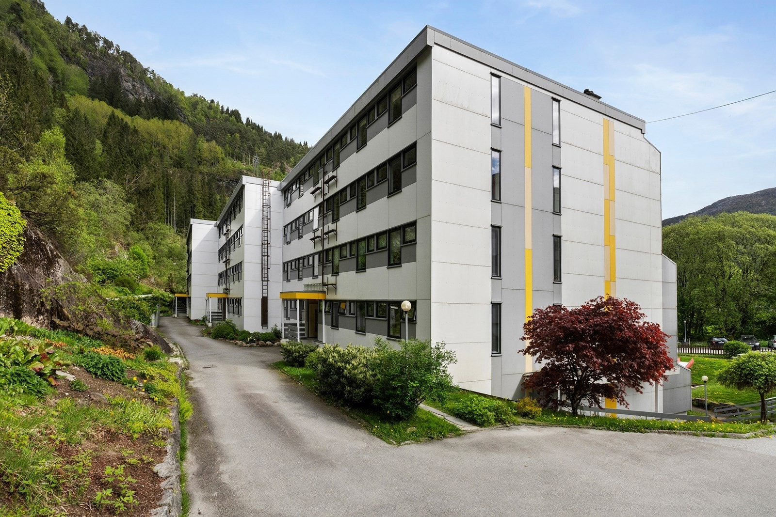 Blokken har inngang på baksiden. På enden av blokken er det dør til parkeringskjelleren hvor leiligheten disponerer en plass. Galleribilde