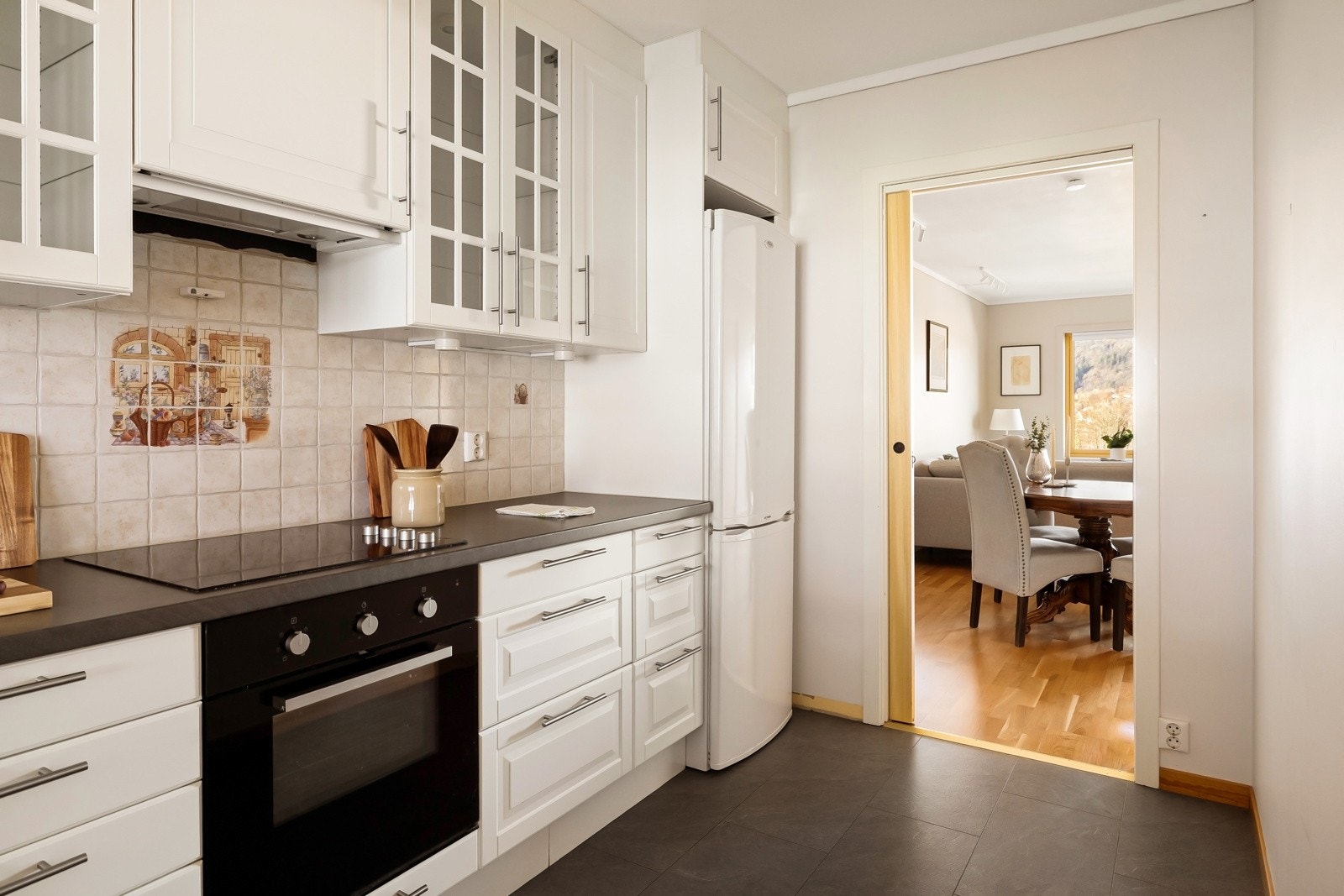 Kjøkkenet ligger som nevnt tilbaketrukket fra stuen, og skyvedøren lar deg enten skjule oppvasken eller holde dialogen i gang med middagsgjestene når den er åpen. Galleribilde