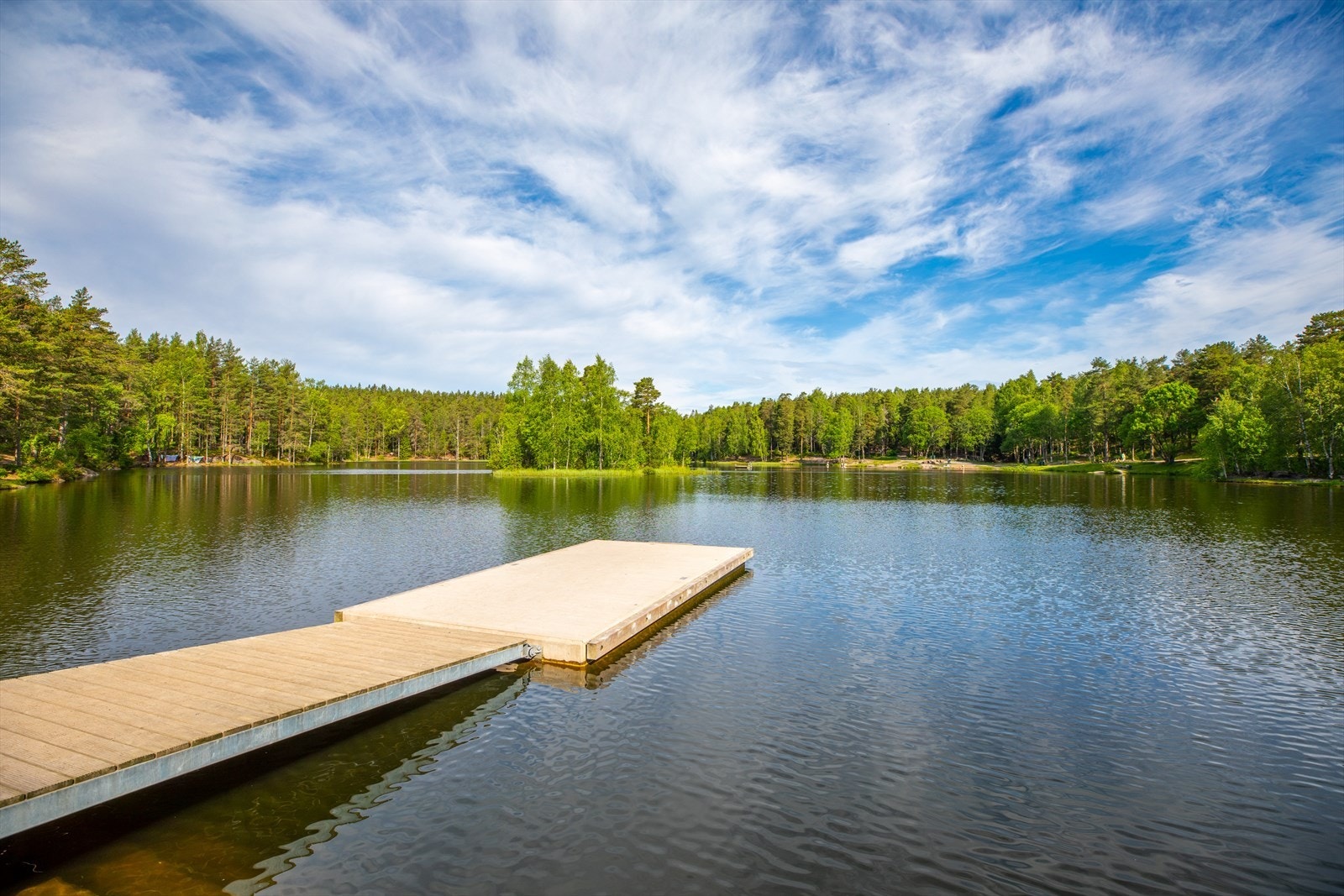 Vesletjern badebrygge er et idyllisk sted for en dukkert på varme sommerdager. Her kan du nyte rolig vann, frisk luft og vakker natur rett ved skogkanten. Galleribilde