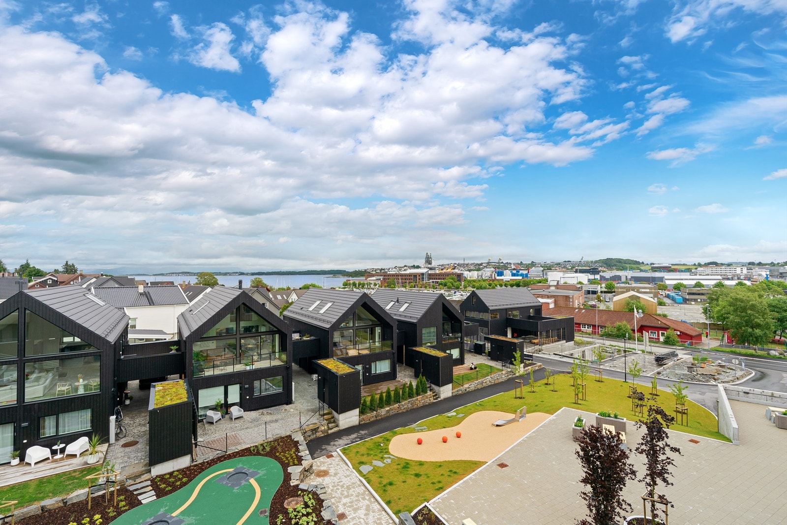 Tunet er parkmessig opparbeidet med fine kombinasjoner av plen, beplantning og hellelagte områder. Kjekt lekeområde for barn og flere benker og sitteplasser. Galleribilde