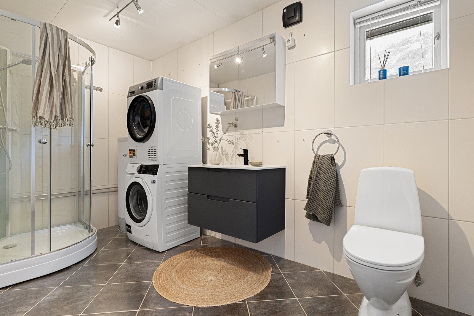 Flislagt bad med dusjkabinett, wc og plass for vaskemaskin. Ny baderomsinnredning fra 2025.