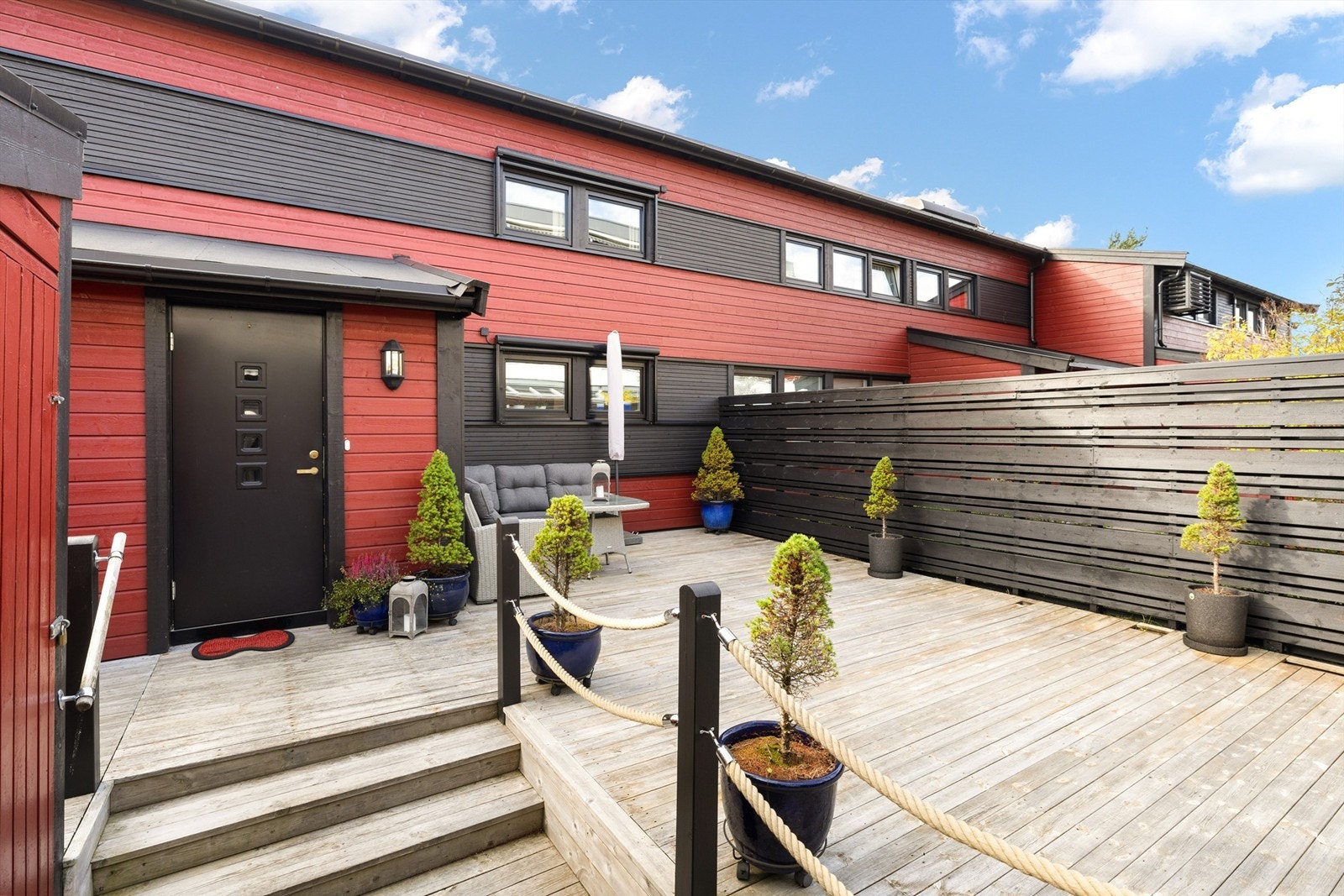 Romslig terrasseplatting og boder ved inngangspartiet. Galleribilde