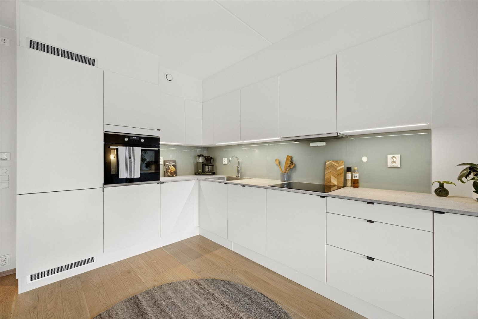 Moderne og tidløst HTH kjøkken med glatte fronter og integrerte hvitevarer. Galleribilde