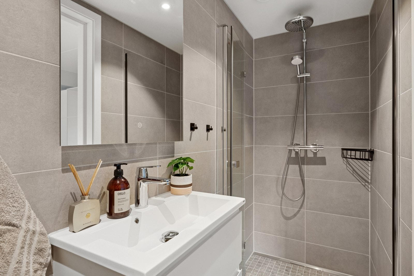 Baderommene har fliser i delikate, beige fargetoner. Galleribilde