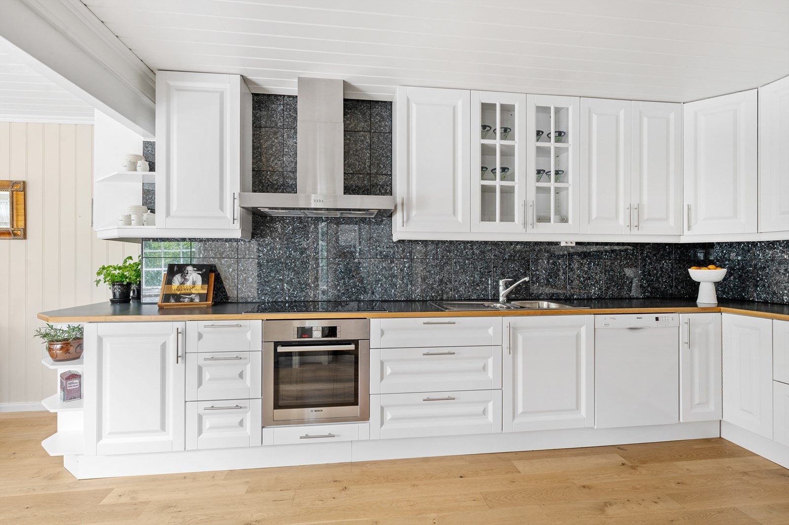 Stort kjøkken med god skap-og benkeplate. Profilerte hvite fronter og integrerte hvitevarer. Galleribilde