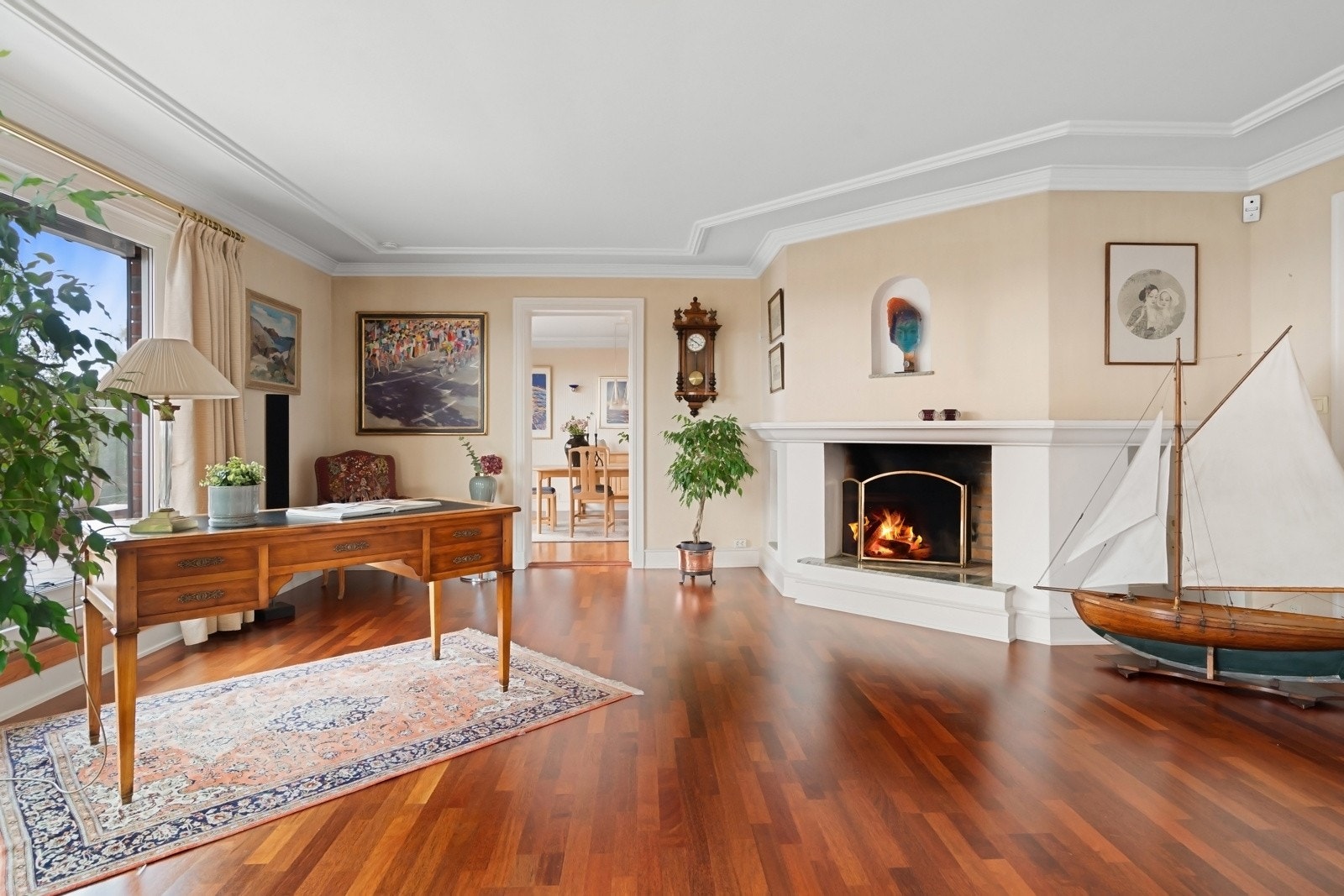 En dekorativ, åpen peis i hjørnet av stuen sørger for ekstra hygge, og det er god plass til fleksibel møblering. Galleribilde