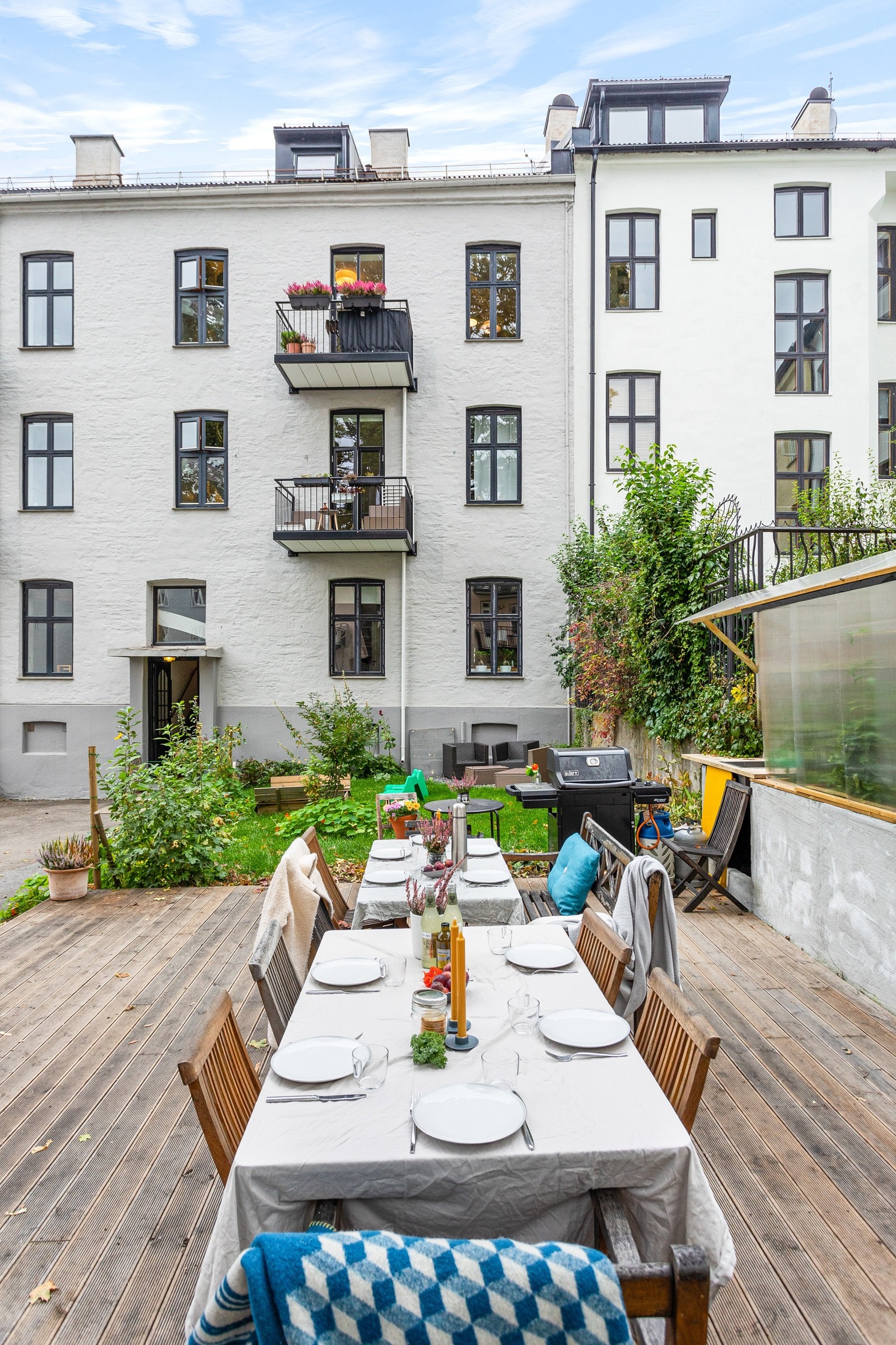 Felles tomt for borettslaget opparbeidet med blant annet asfaltert bakgård, parkeringsplasser, trær, gressplen, prydbusker og diverse beplantning. (arkivbilde) Galleribilde