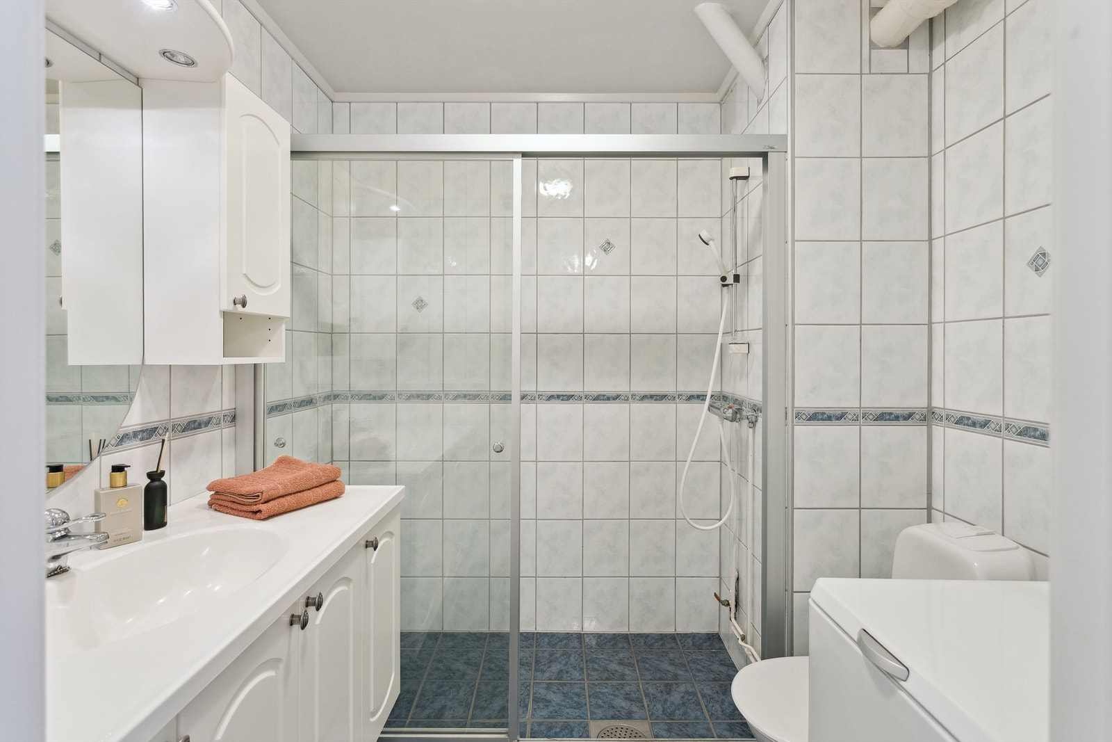 Pent og flislagt bad med romslig dusjnisje med glassvegg- og dør. Det er opplegg til vaskemaskin. Vaskemaskin medfølger Galleribilde