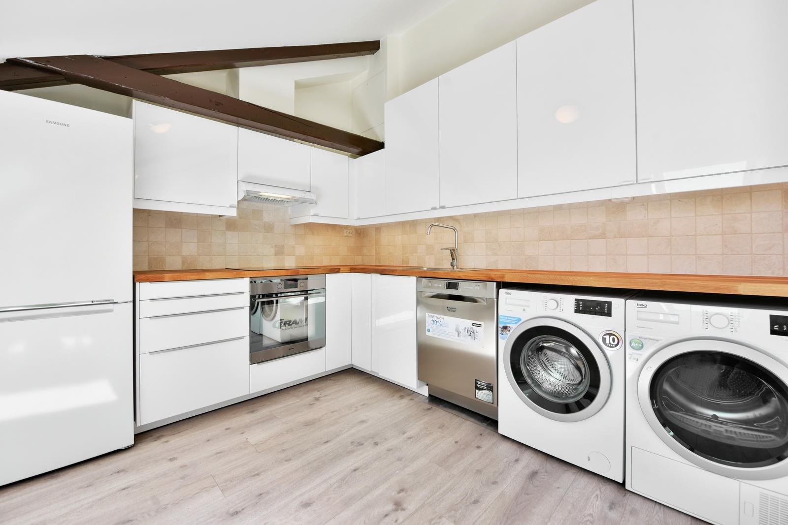 Lyst kjøkken med godt av skap og benkeplass. Galleribilde