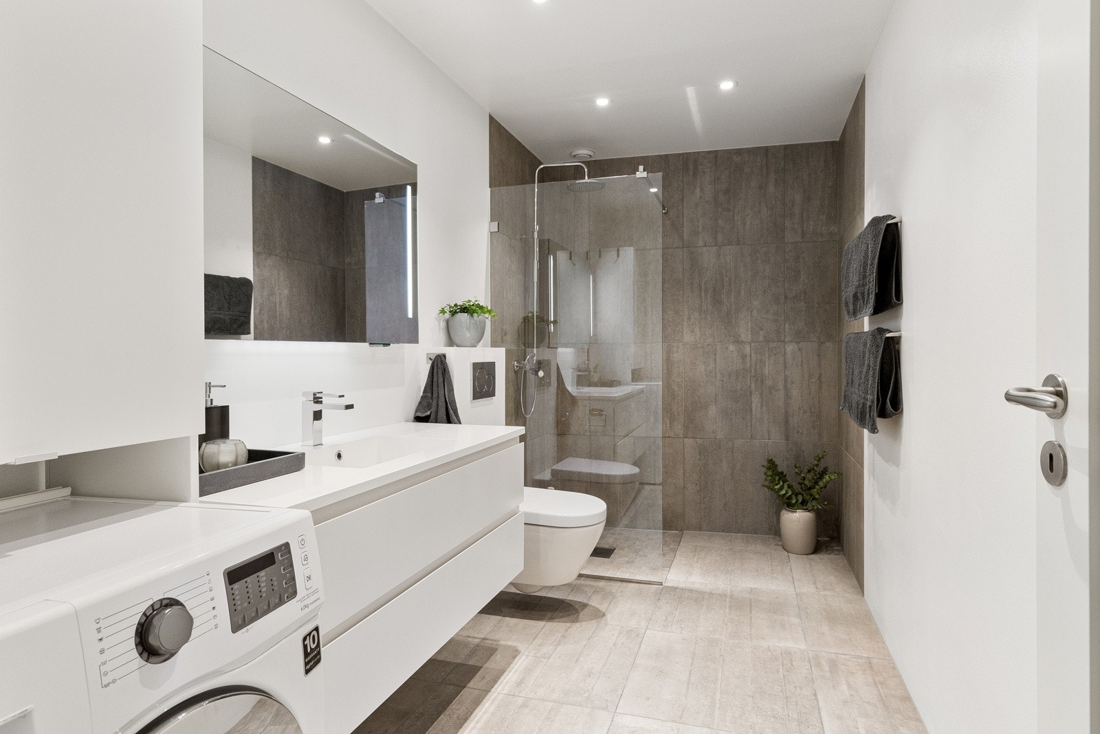 Badet fremstår som moderne og innbydende, med grå fliser på gulv og vegger samt behagelig gulvvarme. Det ble pusset opp i 2014 og holder en gjennomgående god standard. Galleribilde