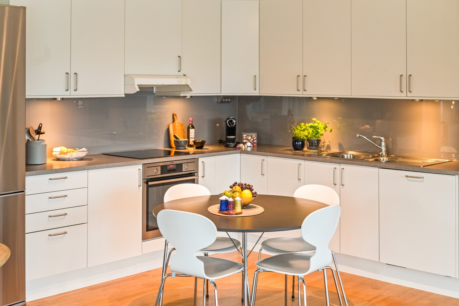 Kjøkken med integrerte hvitevarer som komfyr, platetopp og oppvaskmaskin Galleribilde